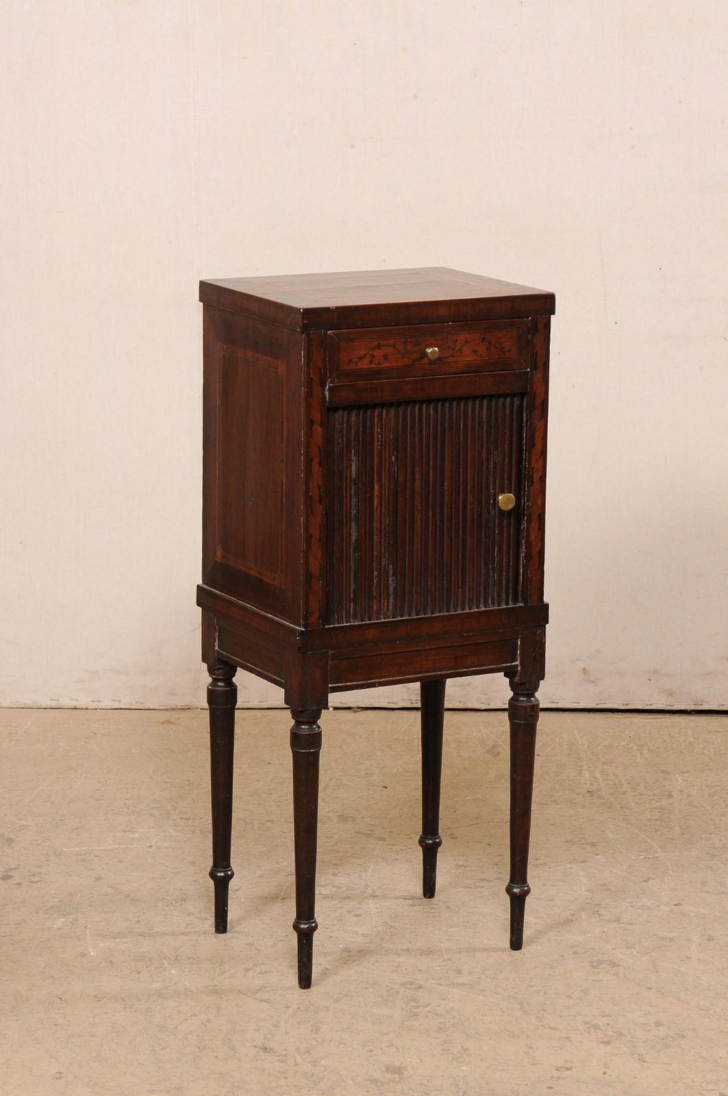 An Italian small-sized walnut comodino from the turn of the 18th and 19th century. This antique side chest/table from Italy features decorative inlay banding at topside, with case housing a single drawer at top (adorn in a sweet foliage motif), over