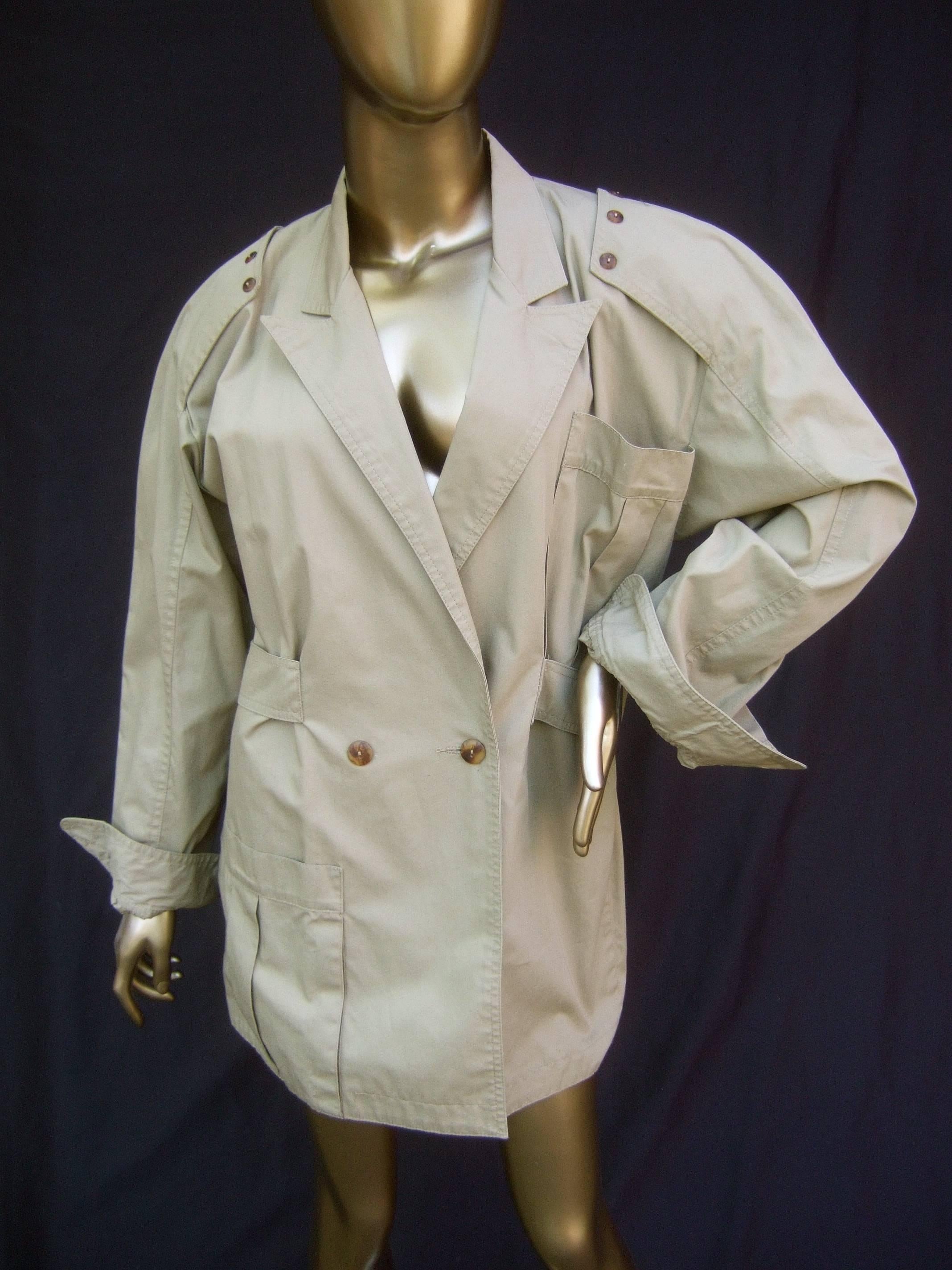 Italian tan khaki cotton sports jacket designed by La Squadra c 1970s
The classic field style jacket is infused with Italian flair
The padded shoulders have an epaulet detail with five
small tortoise shell lucite buttons

Designed with a single deep