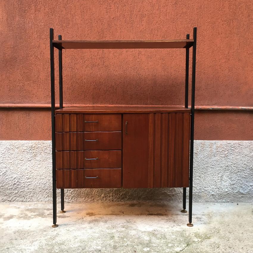 Italian teak and brass and metal cabinet, 1970s. Self-supporting cabinet with container equipped with hinged doors, four drawers and a high shelf metal uprights with brass tips.
 