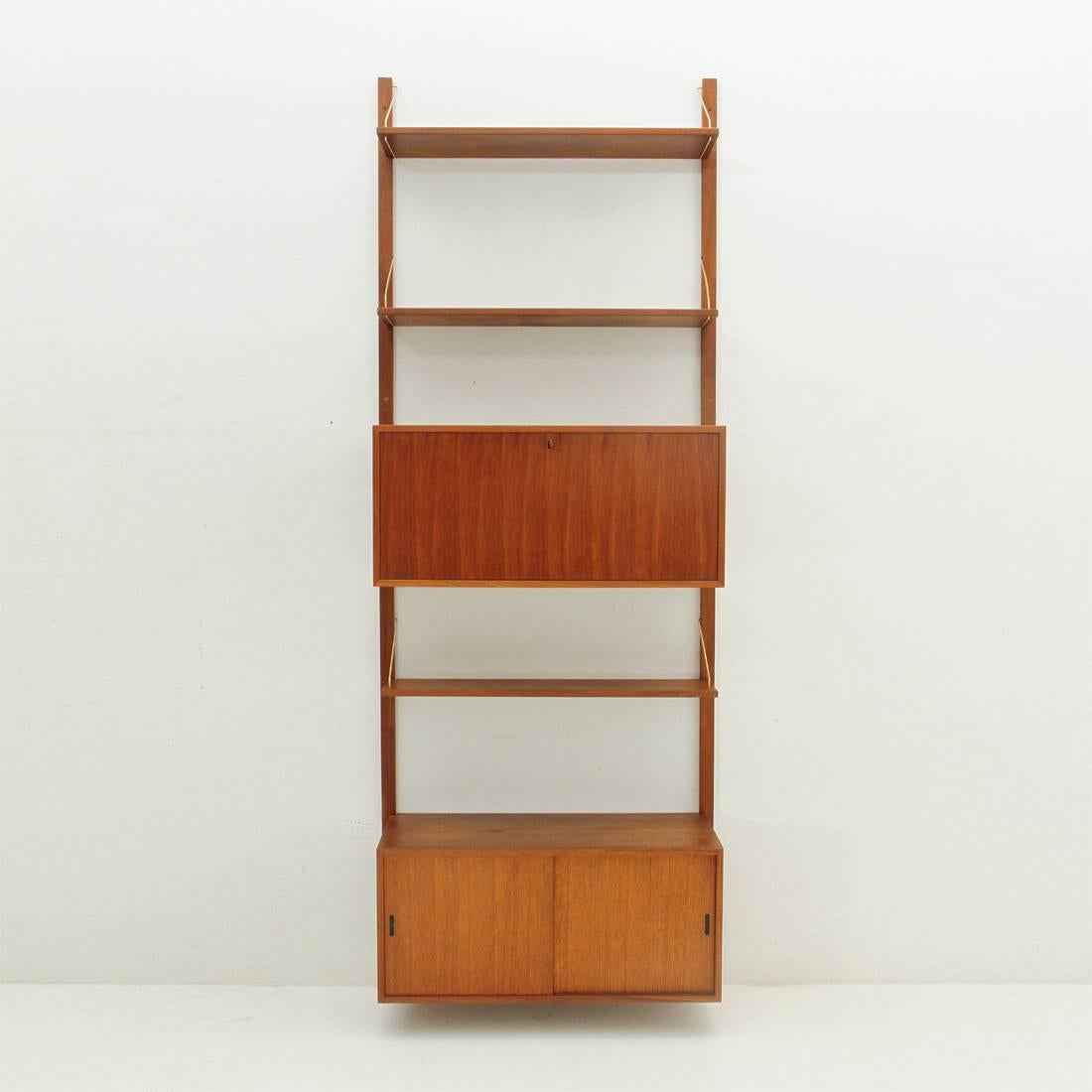 Italian library of production of the 1950s.
Wooden uprights.
Shelves in teak veneered wood.
Hooks in brass rod.
Flip compartment and compartment with doors.
Good general conditions, some signs due to normal use over time.

Dimensions: width
