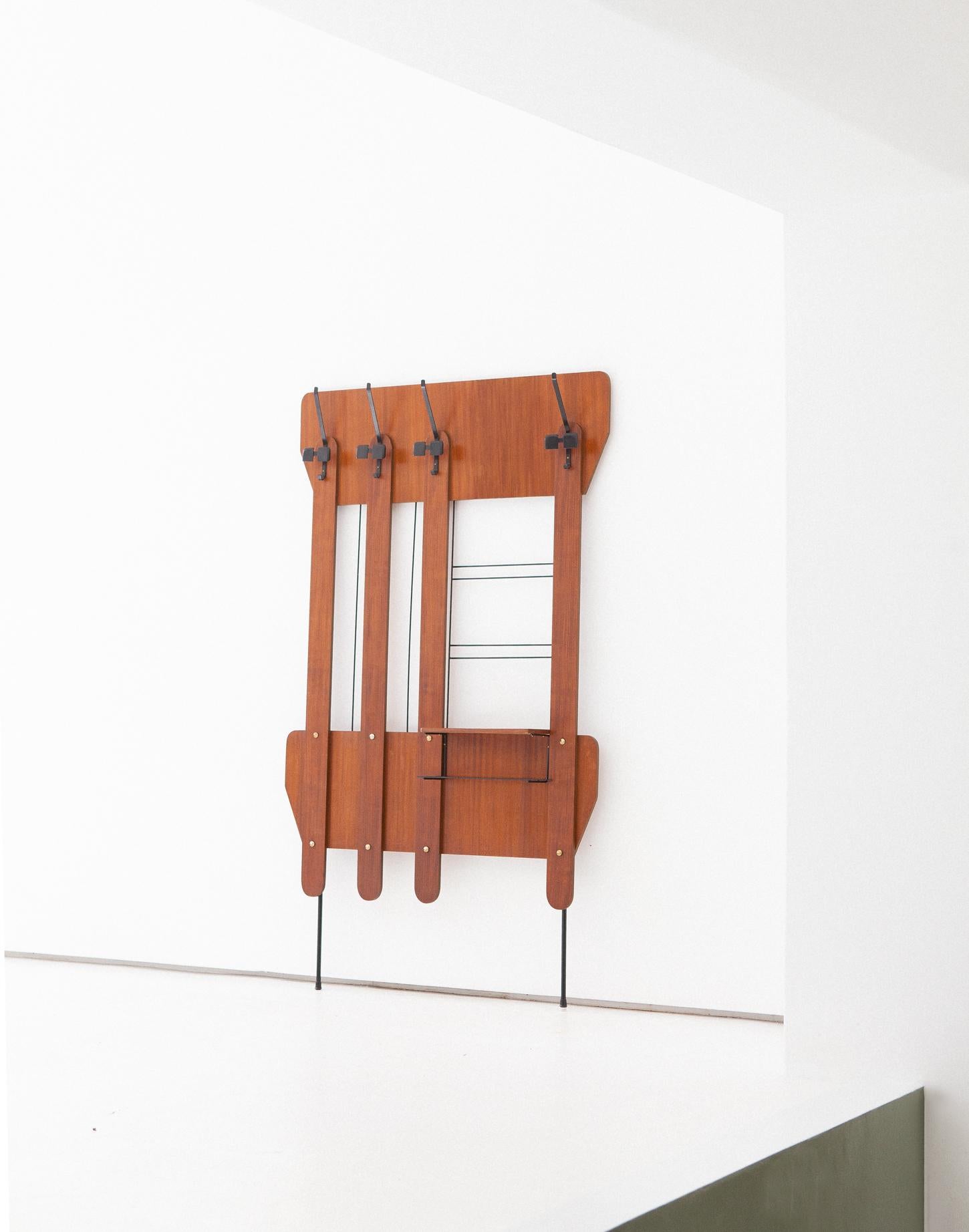 Clothes stand, manufactured in Italy in the 1950s 
This coat and hat hook is made of teak with iron black enameled frame. 
Mid-Century Modern wall unit with empty tray .
Completely restored, only light and pleasant signs of age are left

