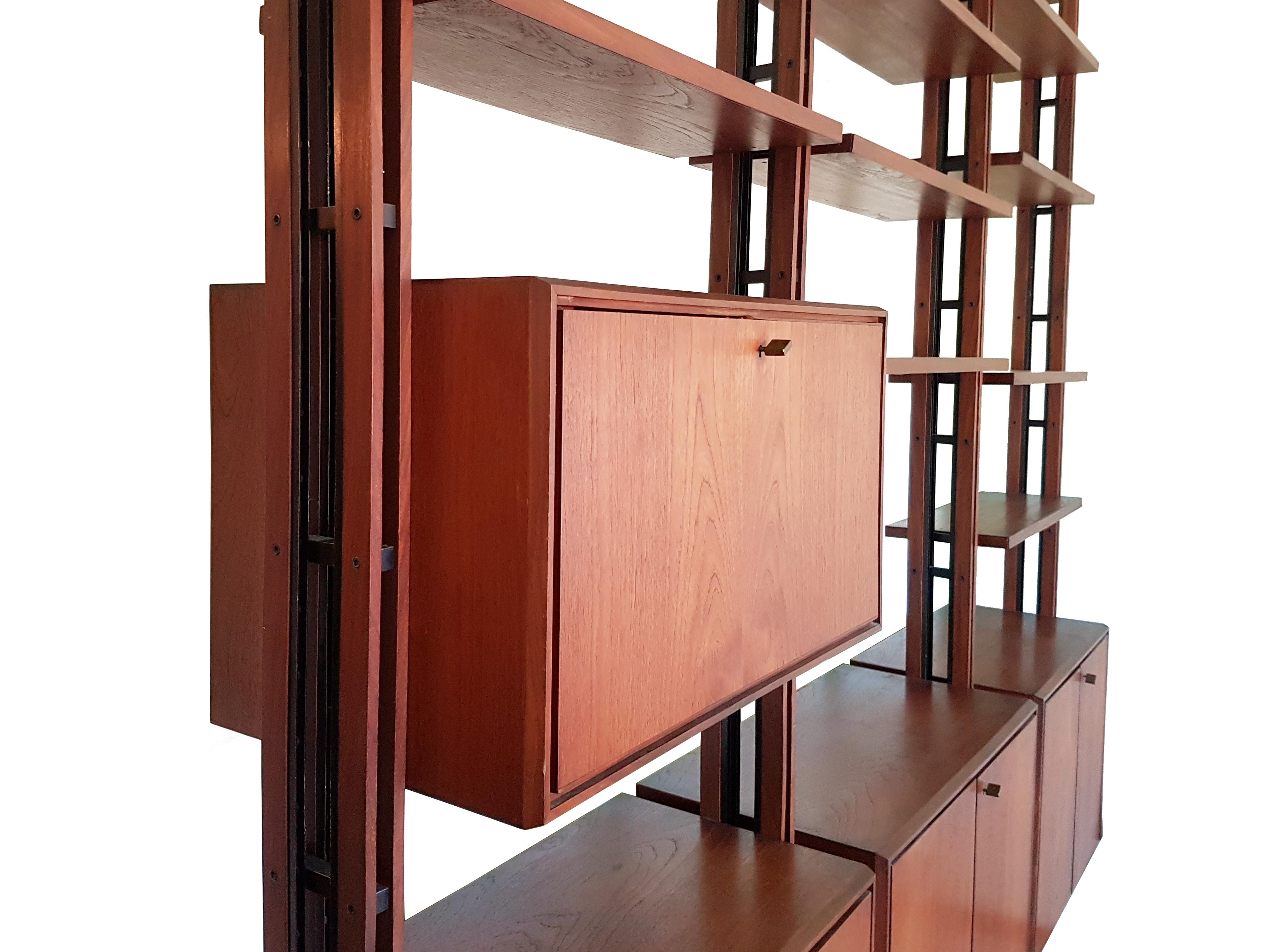This bookshelves was produced in Italy in the 1950s. Thanks to its adjustable height (285-310 cm) it can be placed against a wall or anywhere in a room, used as a space divider.
It is composed by 4 vertical upright, 4 cabinets (3 with doors and