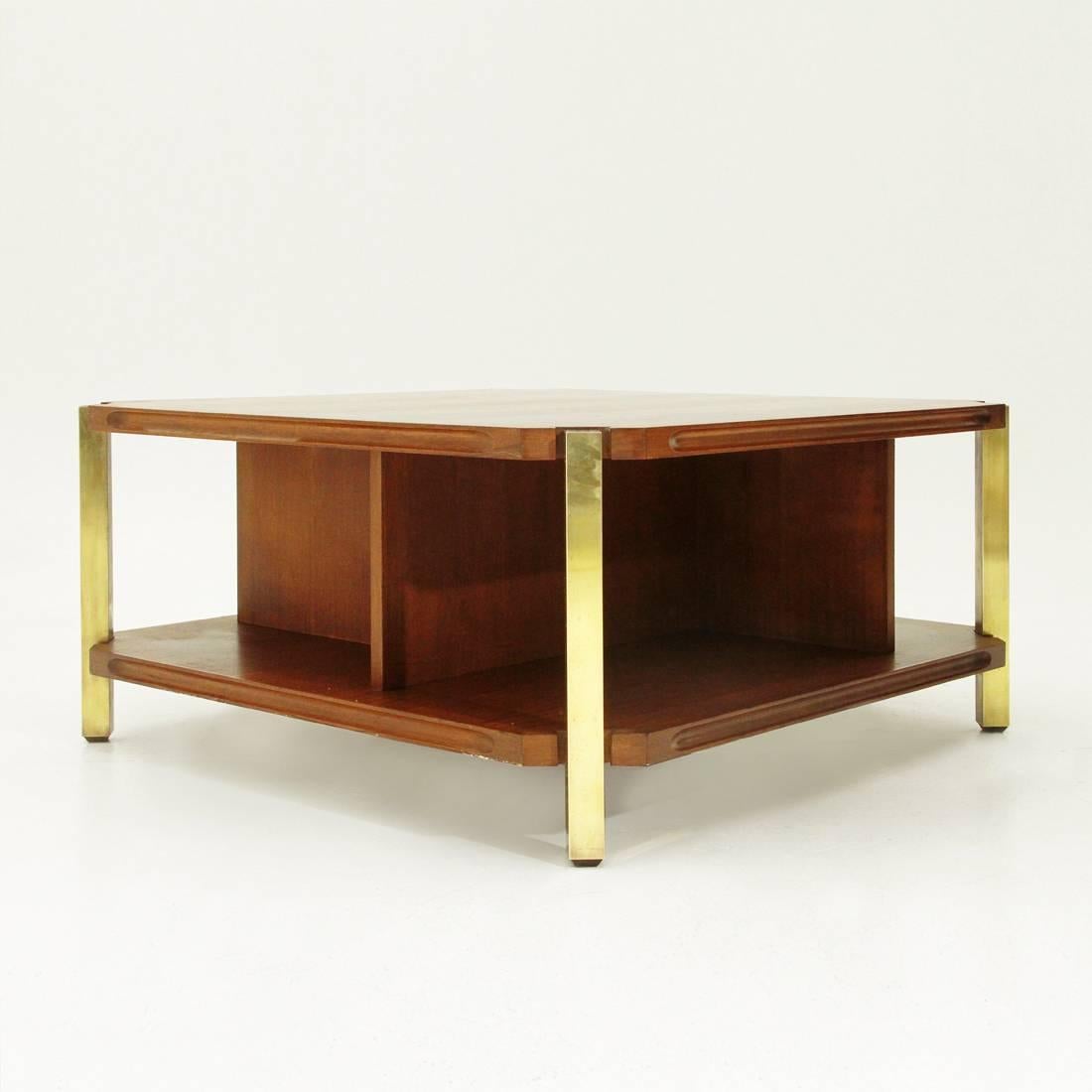 Coffee table of Italian manufacture produced in the 1960s.
Teak veneered wood structure.
Square-shaped tops with cut corners.
Borders with lateral recesses.
Partition walls between the two floors.
Wooden legs lined in brass.
Good general