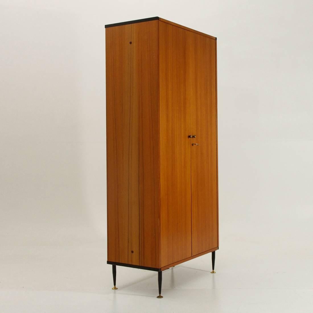 Wardrobe produced in the 1960s by AV Arredamenti Moderni.
Teak frame, corners in black painted metal section.
Legs in black painted metal with adjustable brass feet.
Brass handles.
Inside the cabinet pull-out hanger, ties hanger, and two
