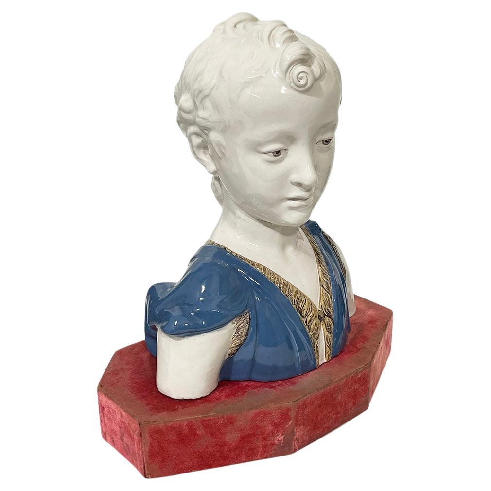 Busto in terracotta di Giovanni Battista, 1900 ca.

Un busto italiano in terracotta, smaltato. Il busto raffigura il giovane Giovanni Battista. Questo busto è smaltato di bianco con abiti smaltati di blu chiaro e poggia su un piedistallo di velluto