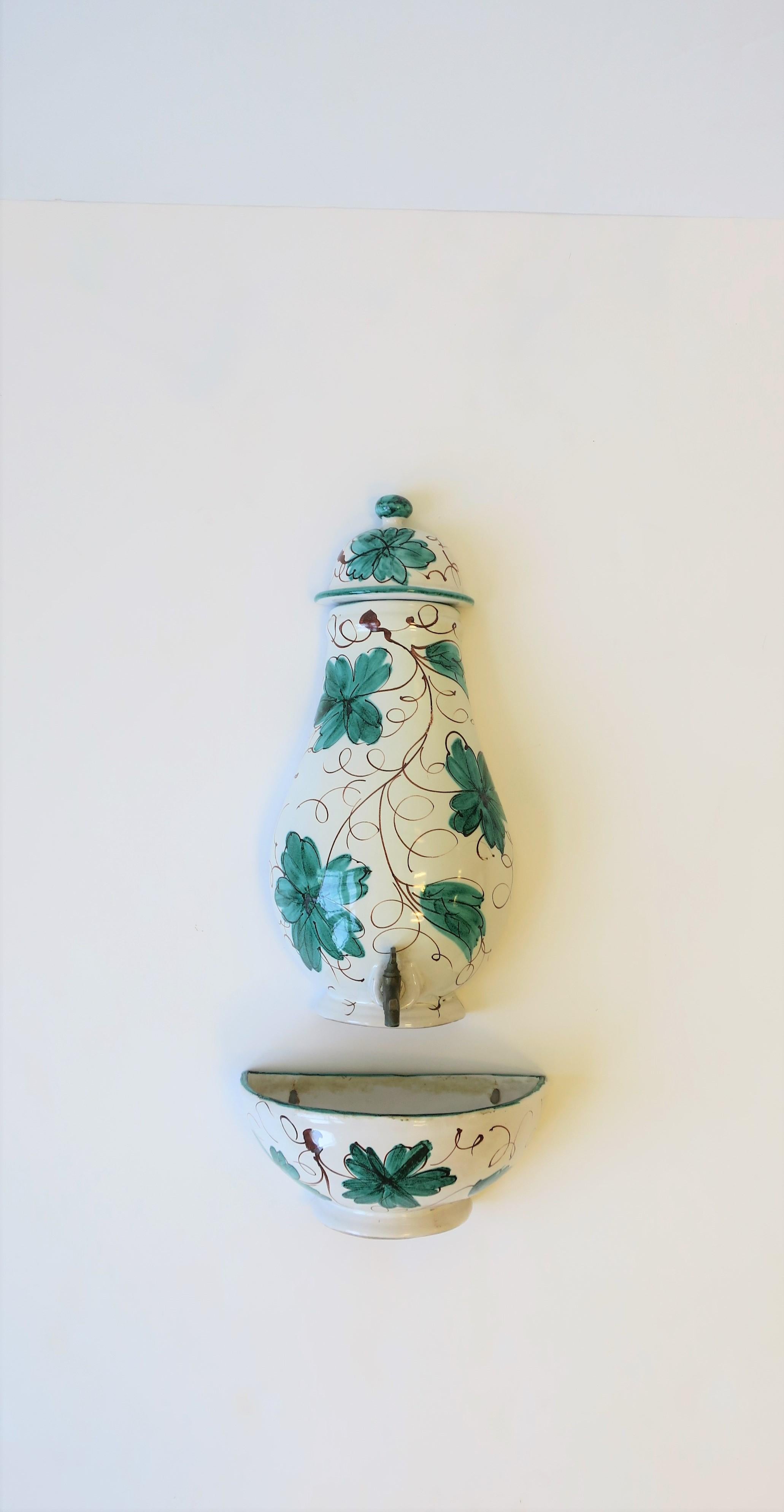 A beautiful hand painted white and green Italian terracotta ceramic and brass wall fountain, circa 20th century, Italy. Piece can hold and dispense water, or another beverage such as tea, lemonade, etc. Fountain consists of three pieces and is wall