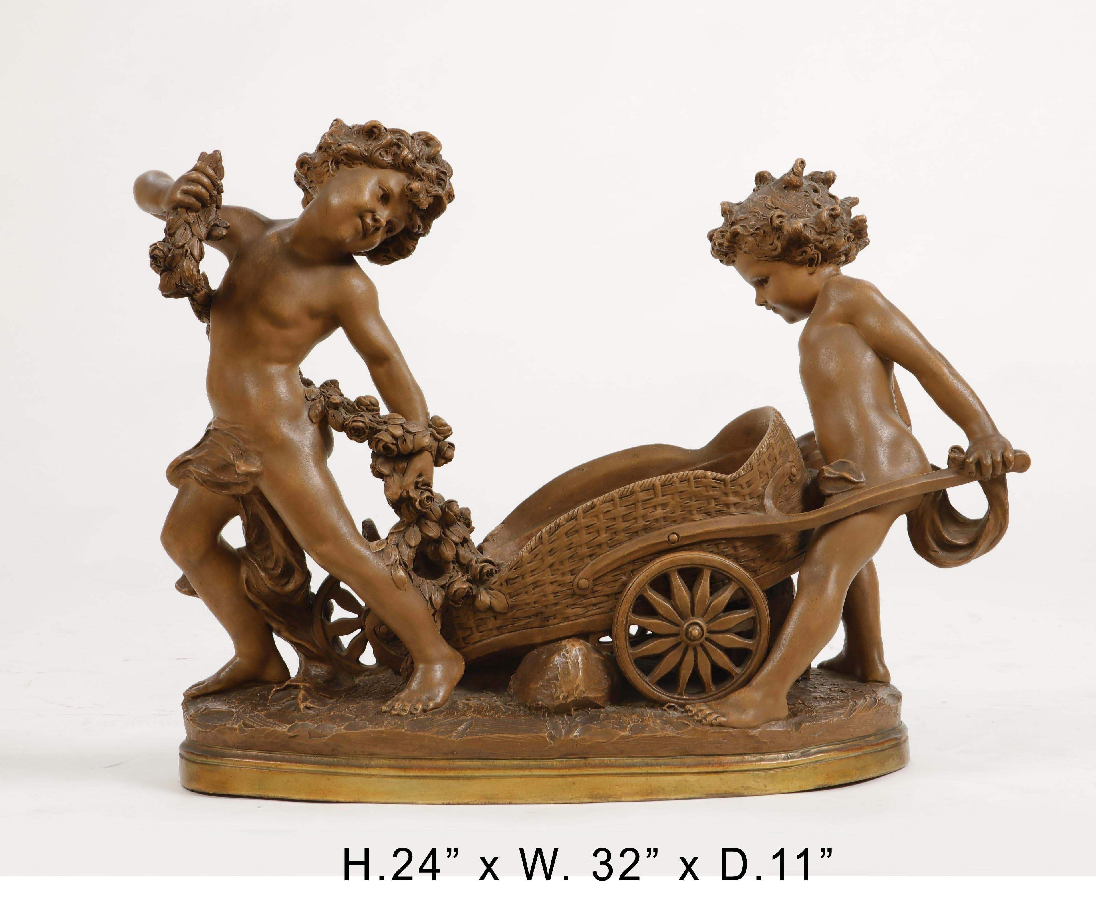 Stunning Italian terracotta cherub figure group centerpiece depicting one cherub holding a swagged garland, another cherub pushing a wheelbarrow, on naturalistic ground-from base,
20th century.
Signed Luca Madrassi.
(Born 1848- Died 1919)
Luca