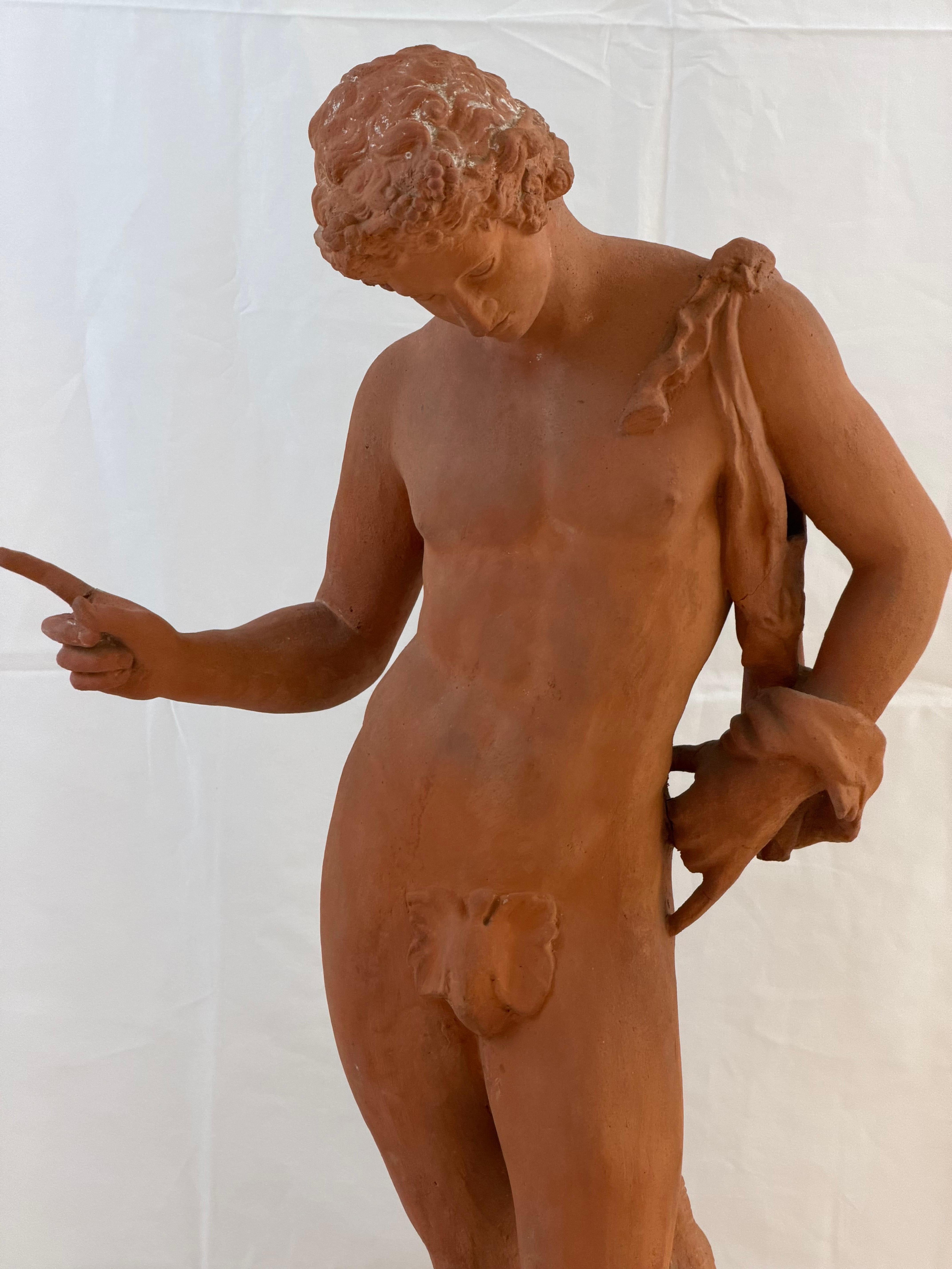 Un'elegante scultura italiana in terracotta raffigurante un giovane classico, circa 1900. Finemente modellata e splendidamente proporzionata, la figura è in piedi in una graziosa posa contrapposta, con lo sguardo abbassato e un braccio teso in un