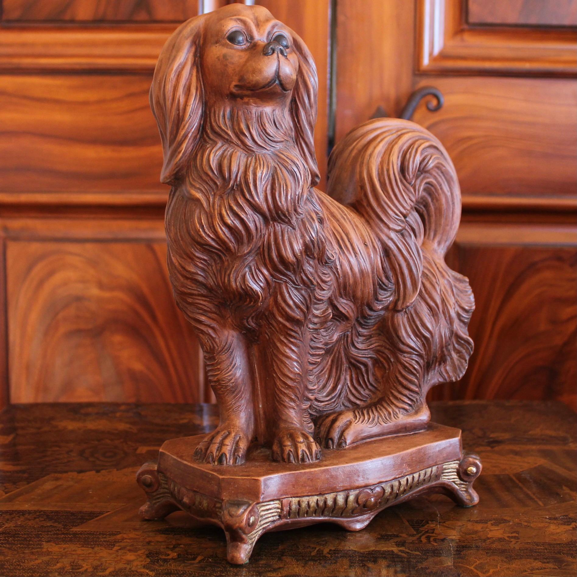 Sculpture italienne en terre cuite de bonne taille représentant un chien - un épagneul King Charles, assis sur un socle, avec une fourrure merveilleusement détaillée et plutôt extravagante, dont le design est très influencé par la tradition des