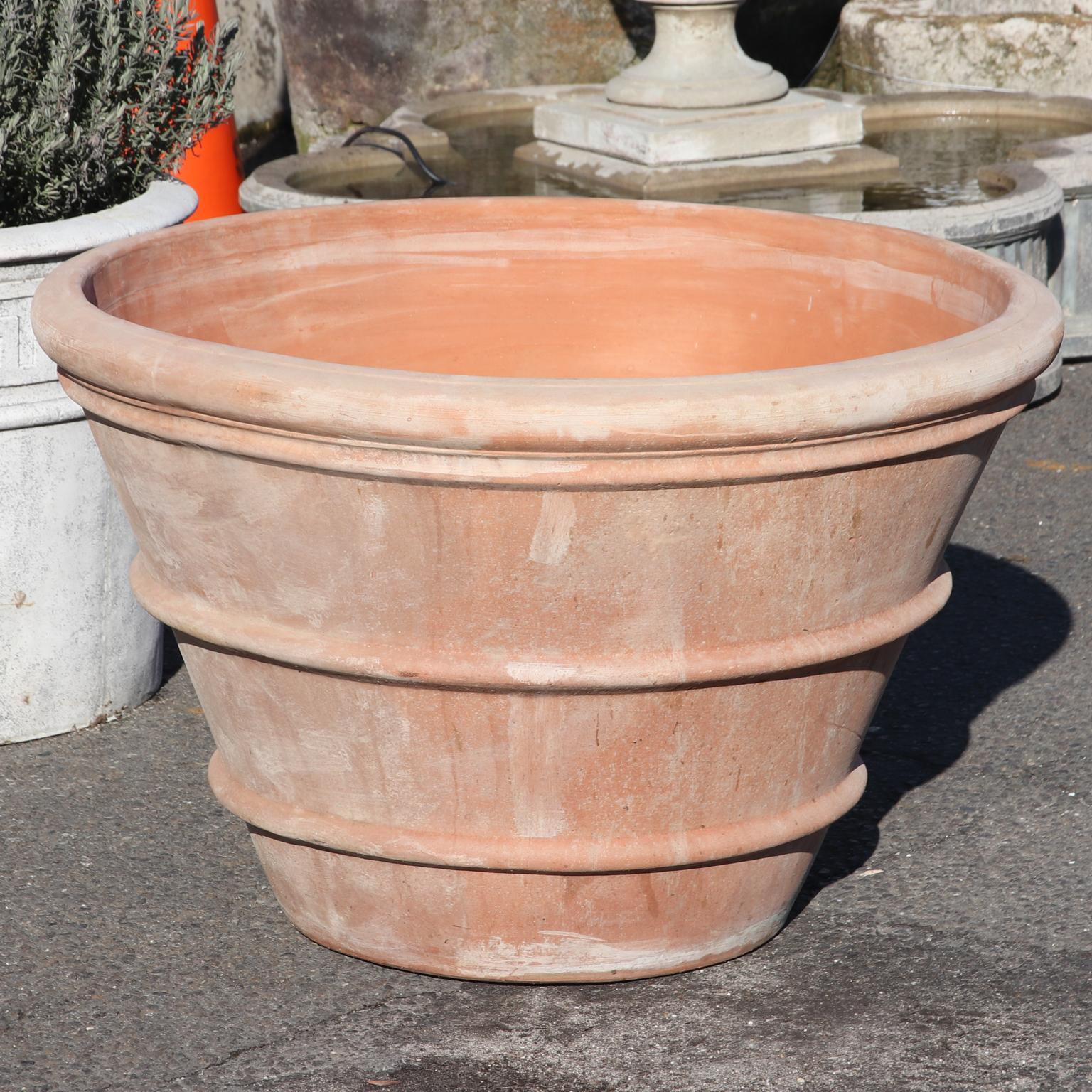 Estate size Italian terra cotta Garden Planter. Generously sized, classically tapered shape, thick rolled edge, and raised ribbed patterns on the sides. Drainage hole is on the base. Stamped Made in Italy. Please note of wear consistent with age.