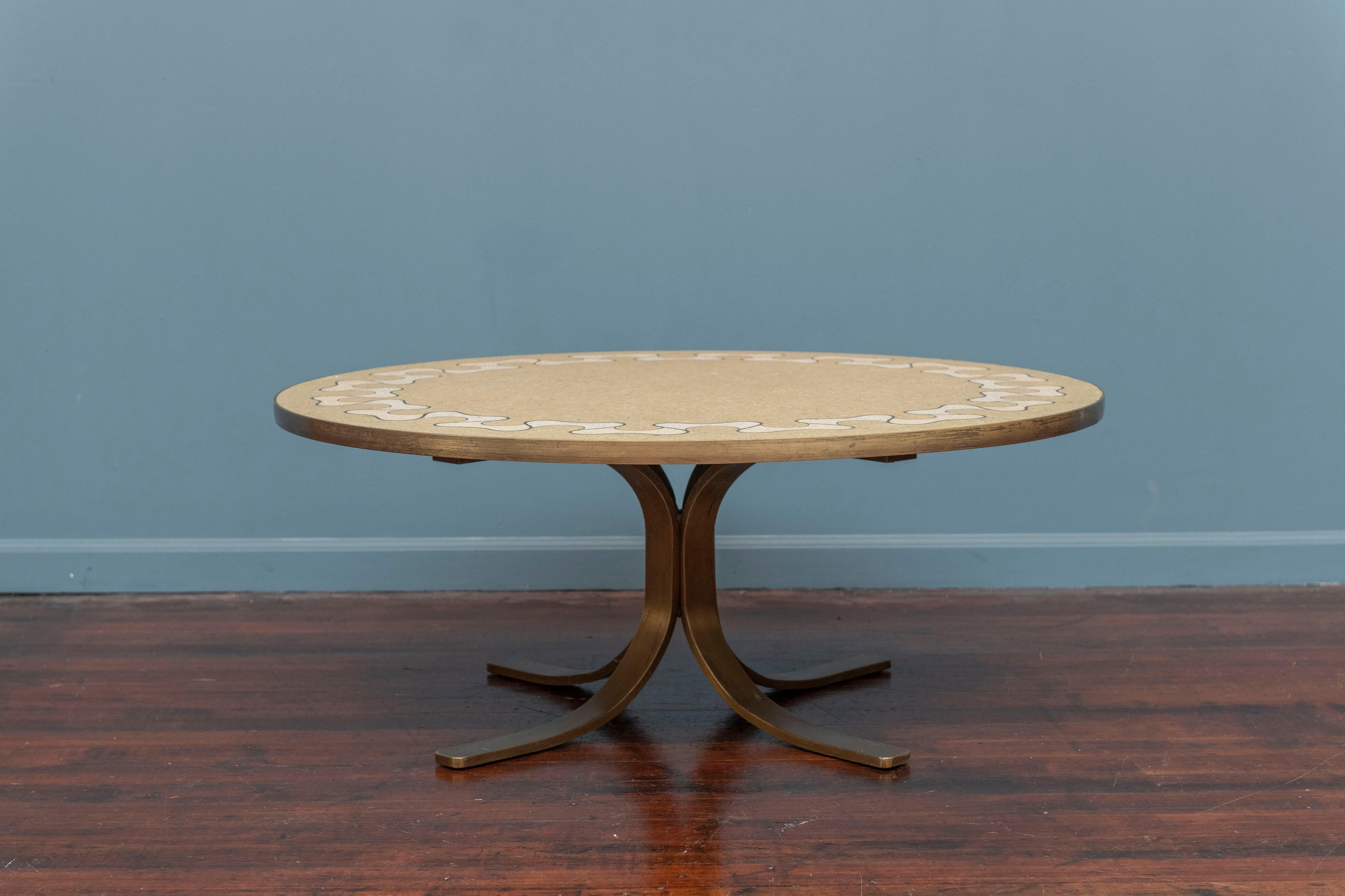Mid-Century Italian terrazzo inlaid round coffee table with a patinated brass four leg base. The inlaid top is a ribbon fold pattern with brass trim.
High quality construction and attention to detail, ready to install.
