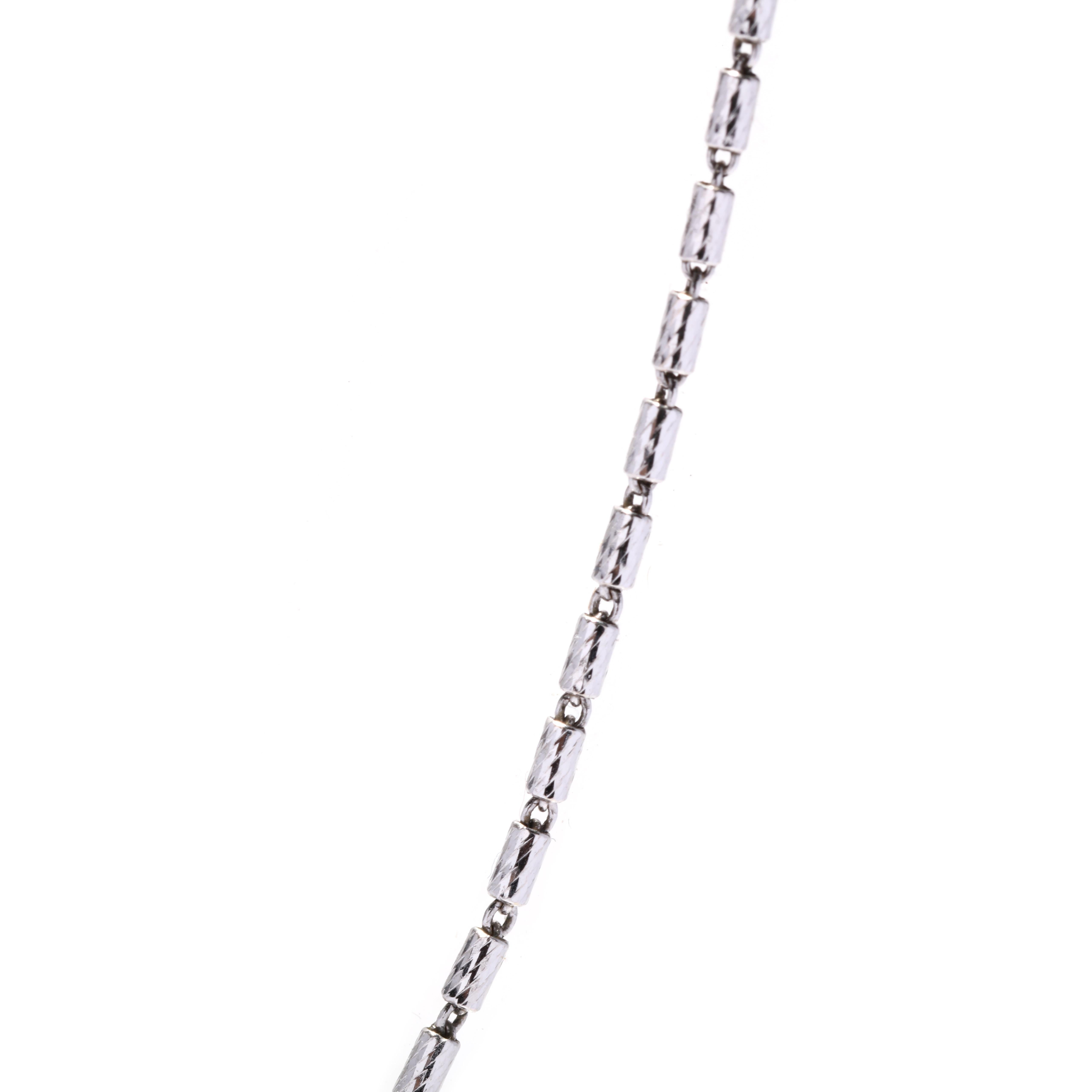 A vintage 14 karat white gold Italian textured barrel bead chain. This thin pendant chain features small elongated barrel beads with a textured finish and with a straight lobster clasp.

Length: 18.25 in.

Width: 1.2 mm

Weight: 2.3 dwts. / 3.6