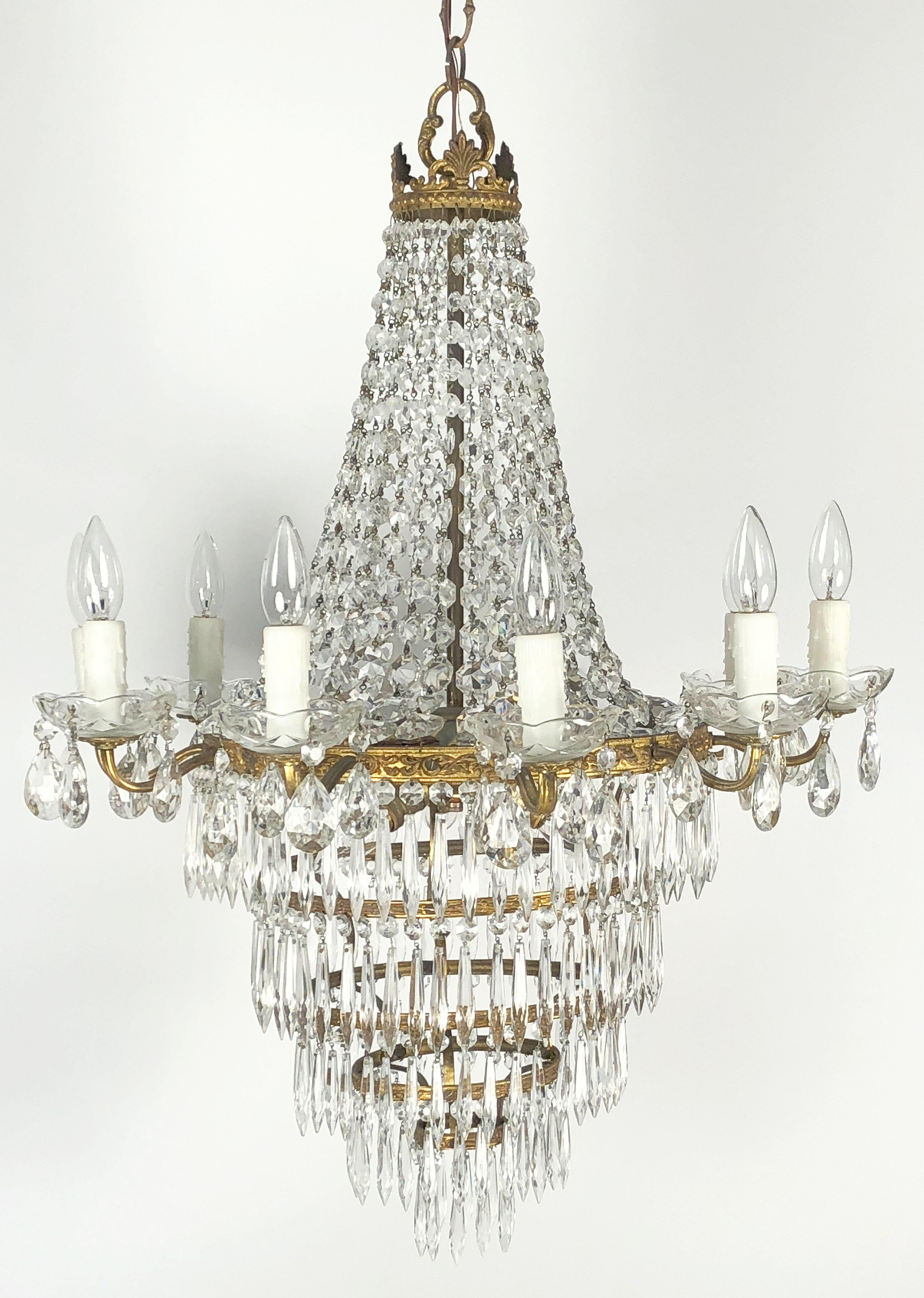 Un magnifique lustre italien à treize lumières en métal doré et cristaux, dans le style Empire, avec une couronne de pendentifs en cascade, avec un anneau de dix lumières autour de la circonférence entourant un centre de trois lumières, et une base