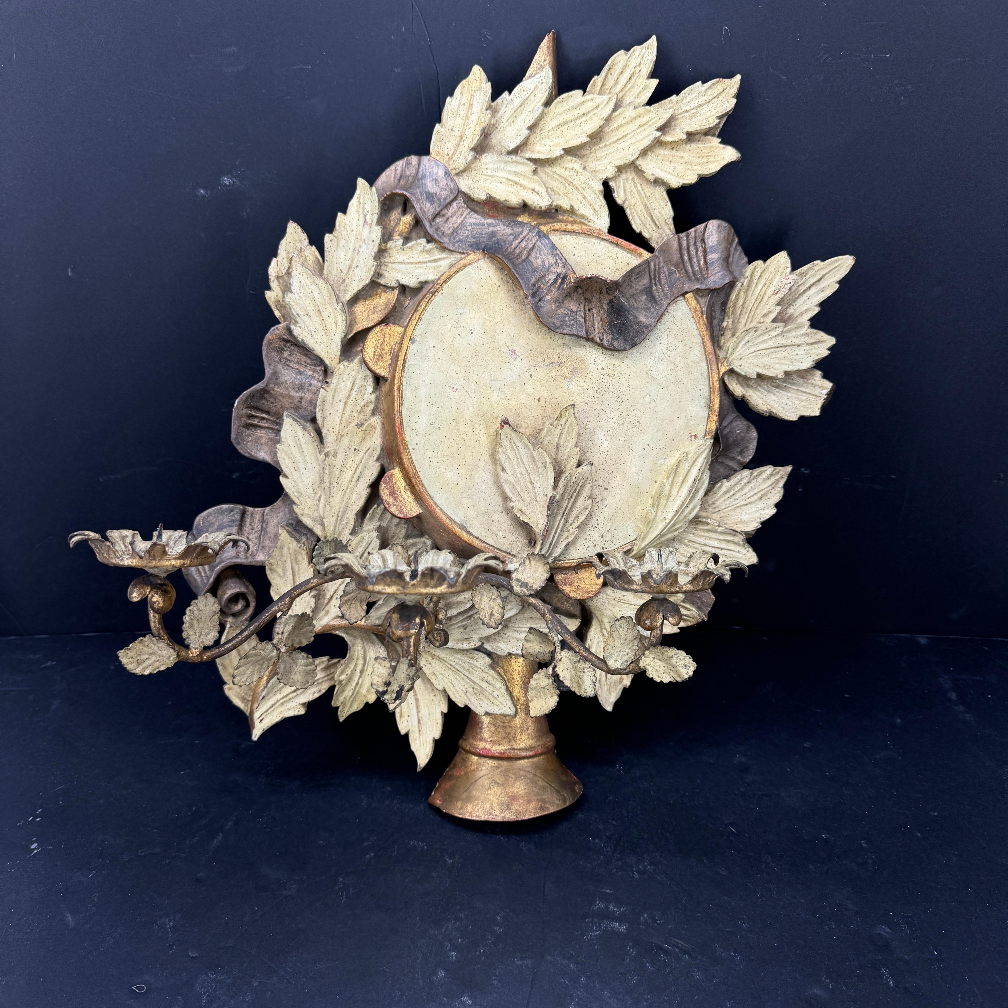 Elegant wooden wall candle sconce with beautiful detail throughout, including leaves and ribbons. This hand-painted gold gilt finish sconce has a very pleasing aged look. This classic candle wall light would enhance any hallway, dining room or