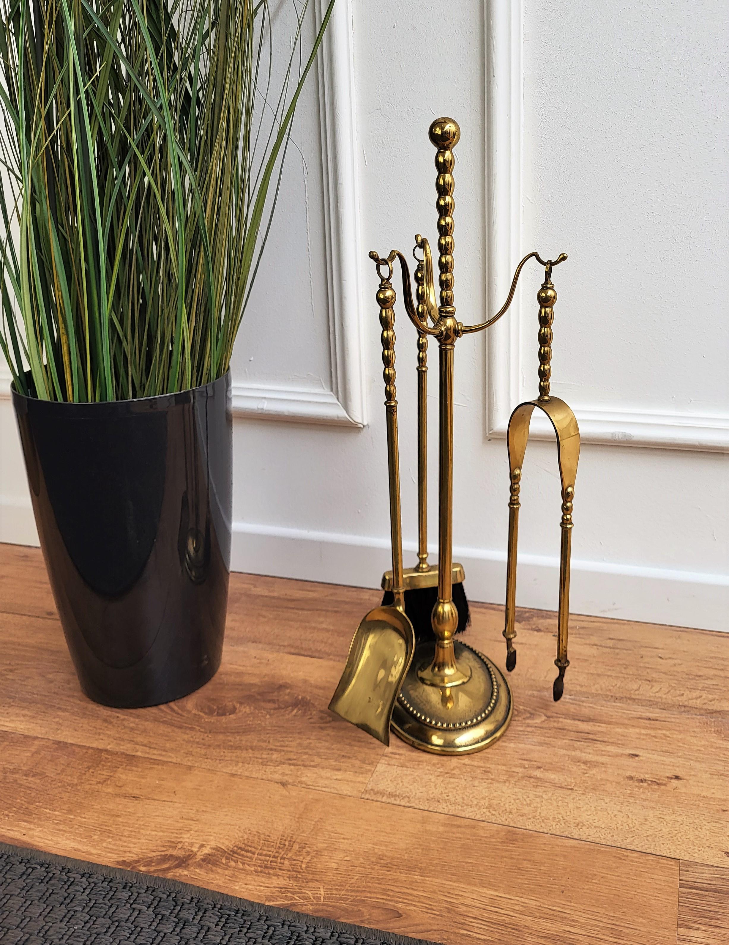 Beautiful Italian brass three-piece fire tool set with stand. The set consists of a poker, a shovel and a pair of tongs, each with an ornate handle such as the stand. 


