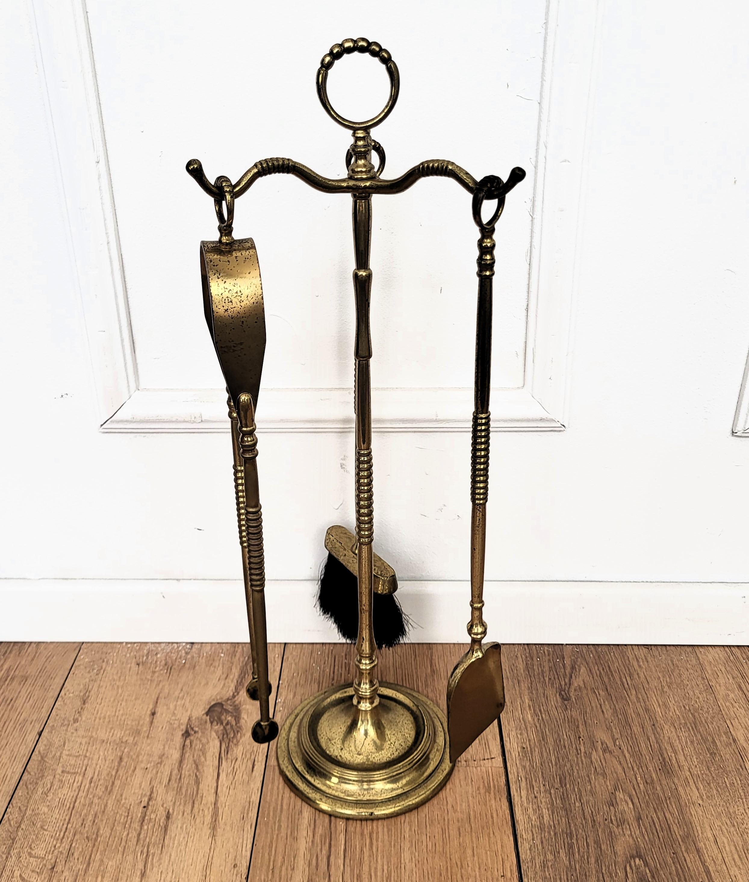 Magnifique ensemble d'outils à feu en laiton italien, composé de trois pièces et d'un support. L'ensemble se compose d'un tisonnier, d'une pelle et d'une paire de pinces, chacune dotée d'une poignée ornée, comme le support. Comme vous pouvez le voir