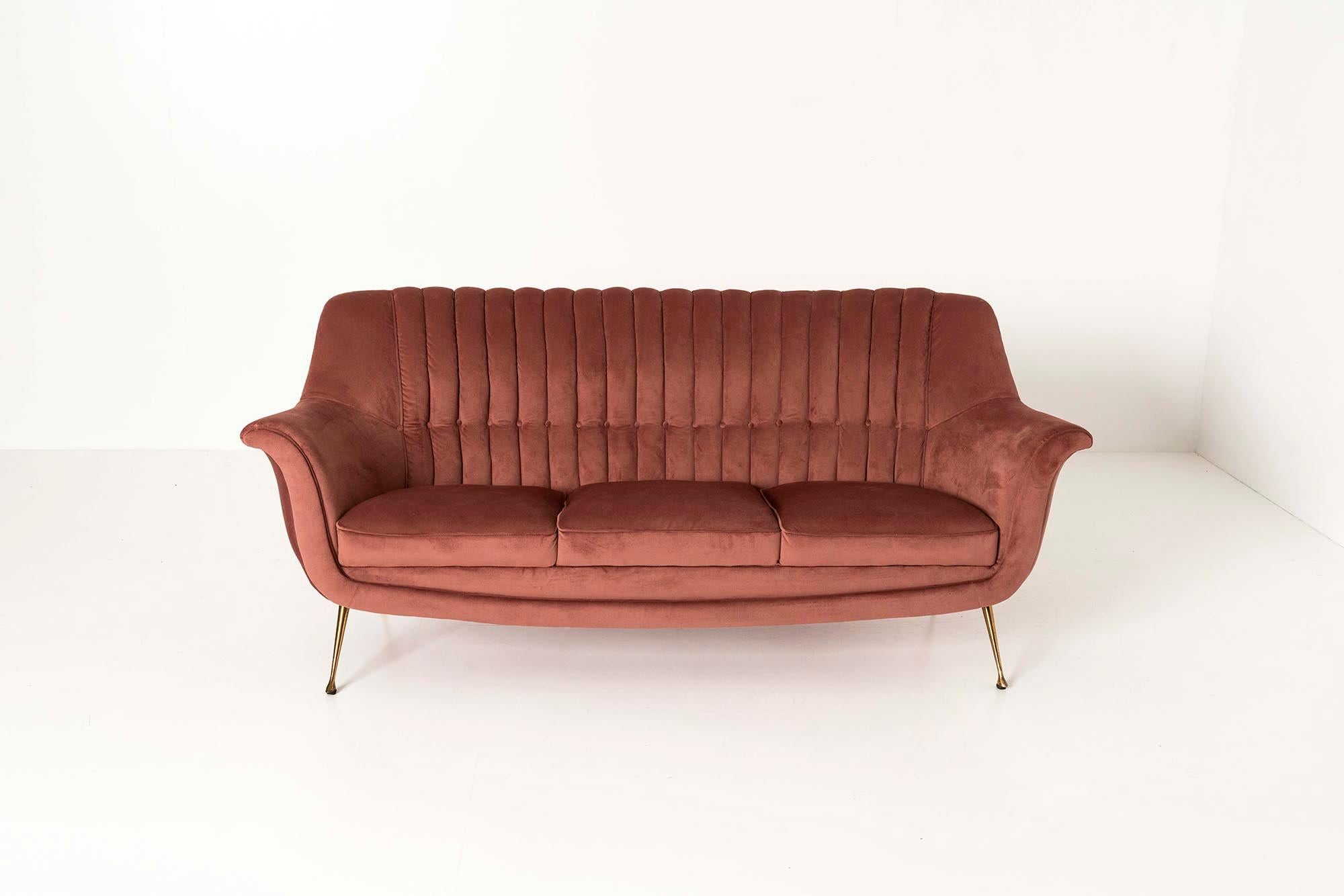Elegant Italian three seater sofa in dark pink velvet from the 1950s. This elegant three-seater sofa would not have looked out of place in a beautiful setting from an Italian film from the 1950s. The backrest is stitched in lines and padded across