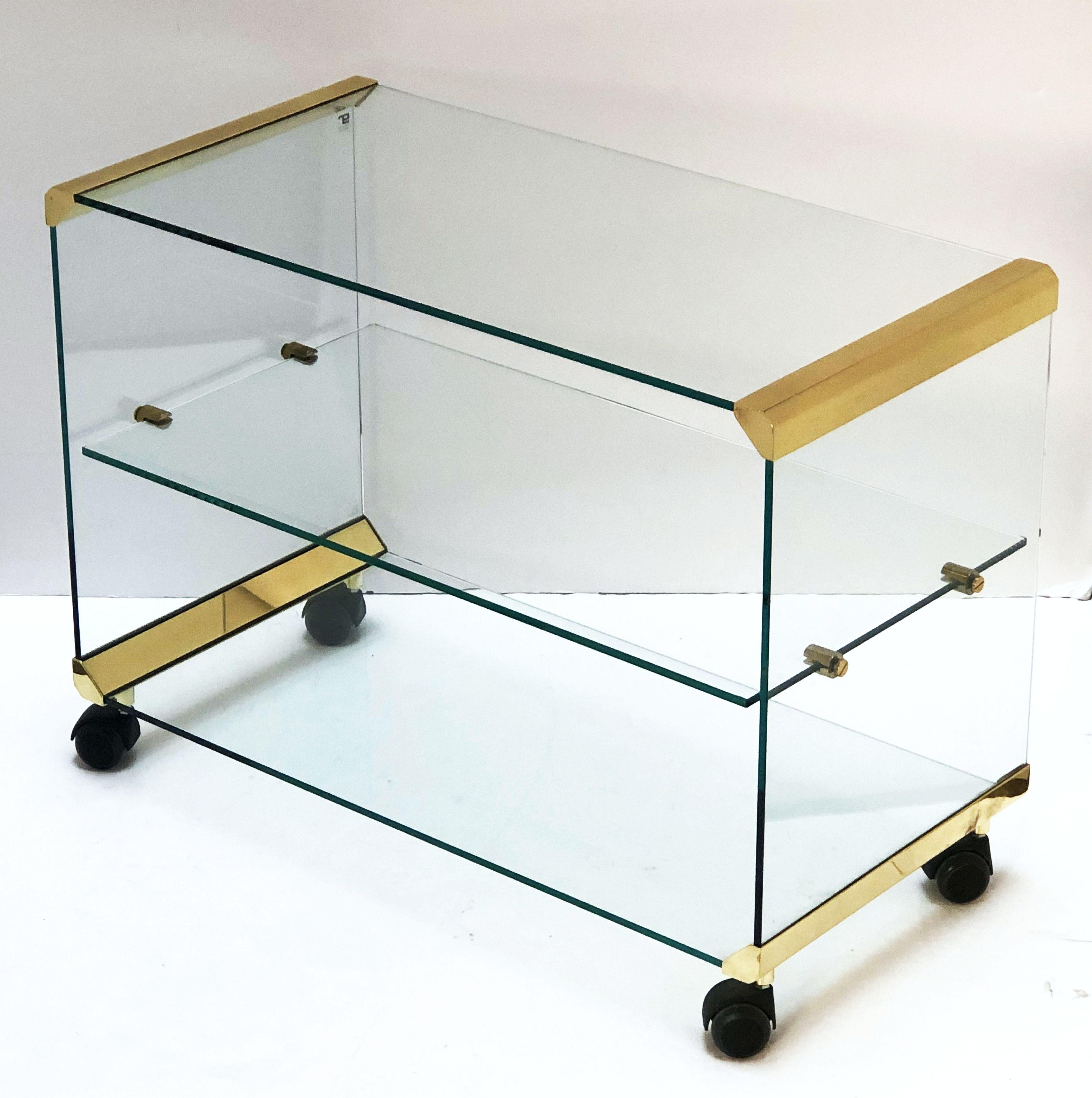 A fine Italian drinks cart (bar cart) or trolley server of glass and brass, in the modernist style, by the celebrated Italian design firm, Gallotti and Radice. Featuring three tiers - the glass structure held together with handsome brass hardware