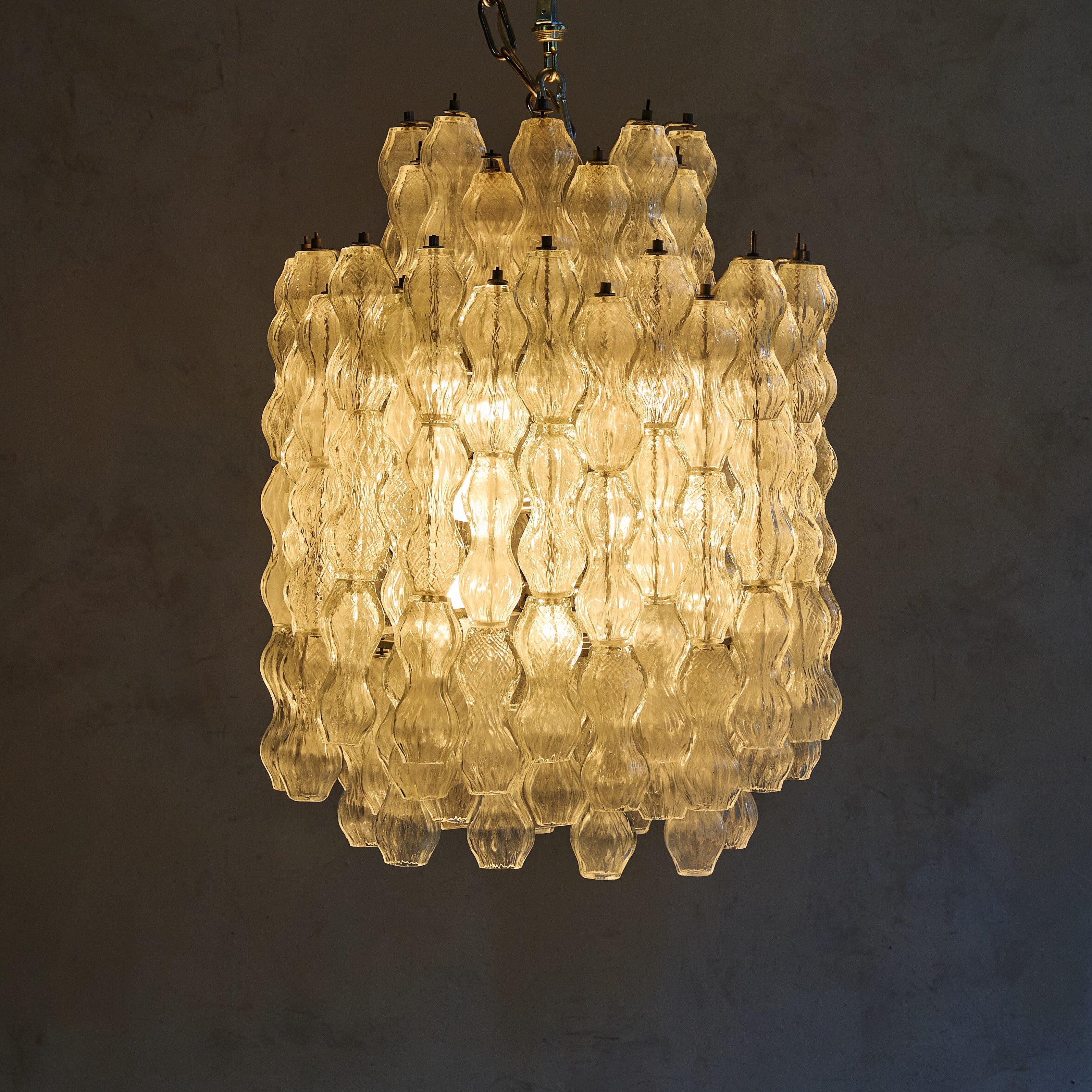 Designed in the 1950s, this Italian Murano glass chandelier embodies the artistry and innovation synonymous with Archimede Seguso. Composed of cascading textured glass drops, this chandelier showcases delicately undulating forms that create a