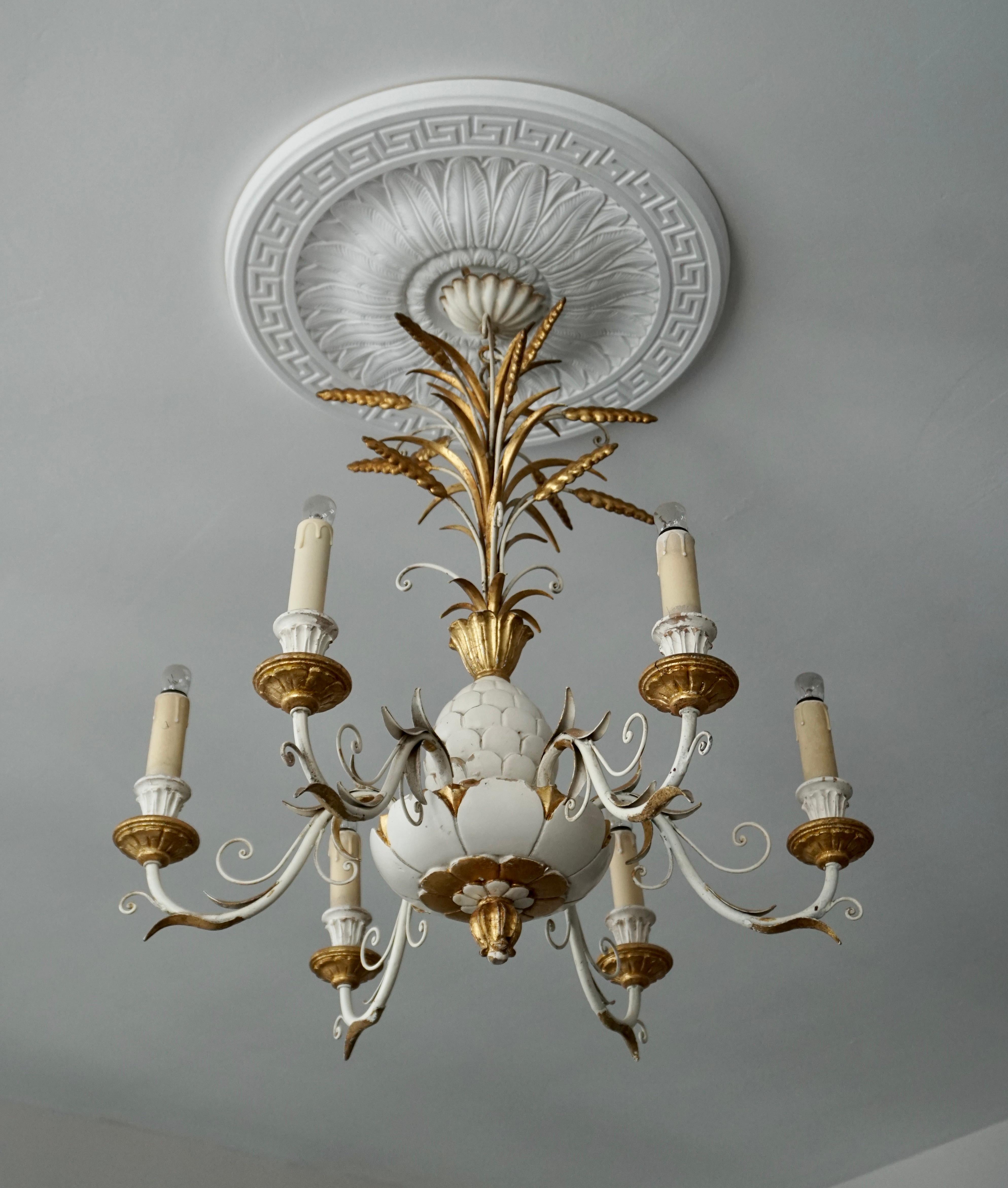 Six light chandelier crafted in wood and gilt and white painted metal in a classic composition with leaves fronds at the top over a tole pineapple. 

Diameter 25