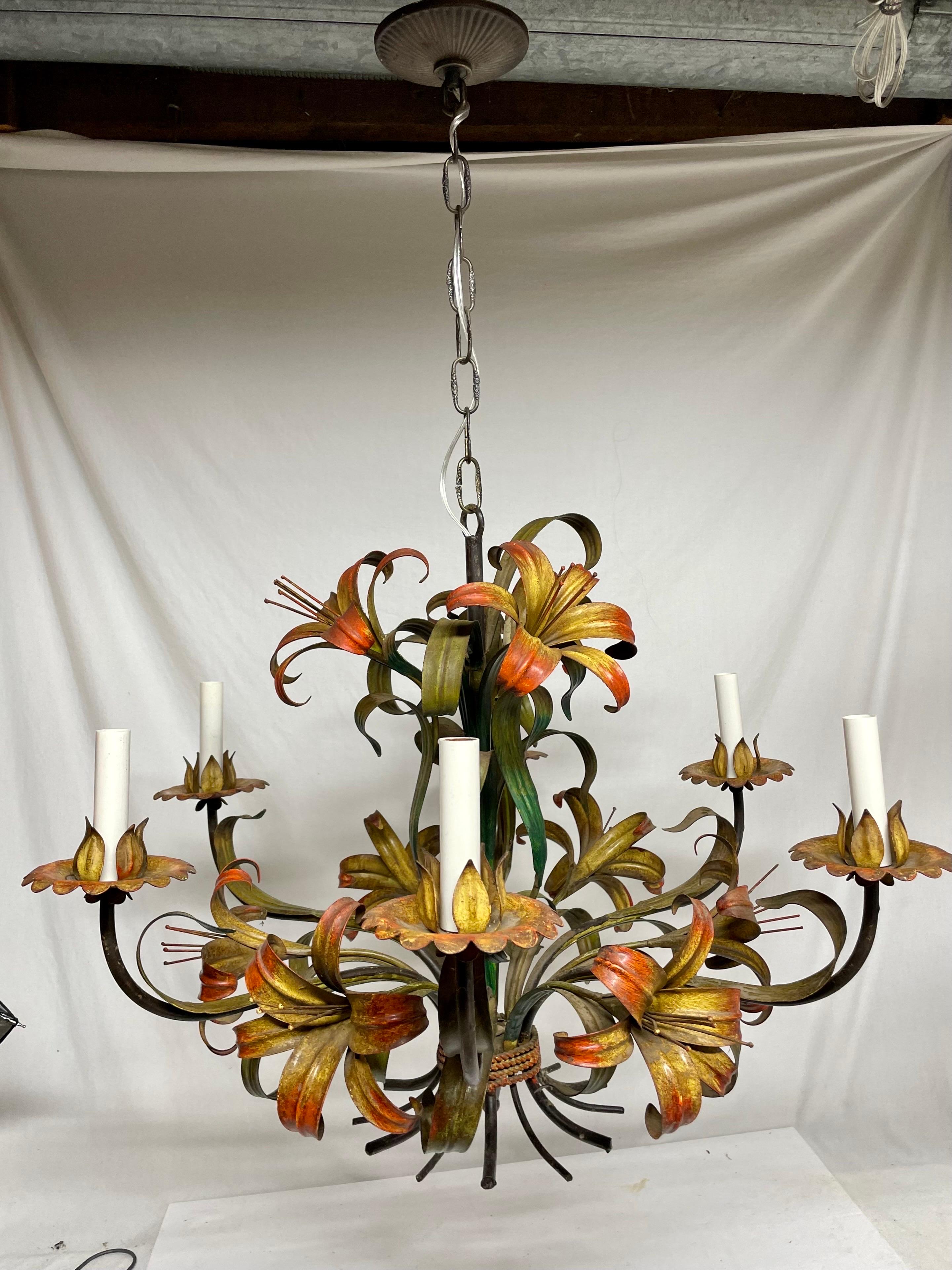 Large scale Italian floral tole six arm chandelier. Lots of  Lilly flowers in yellows and reds with green leaves. Slight chipping paint that adds to the character. Rewired with x long wire if more length is desired and in good working condition.
