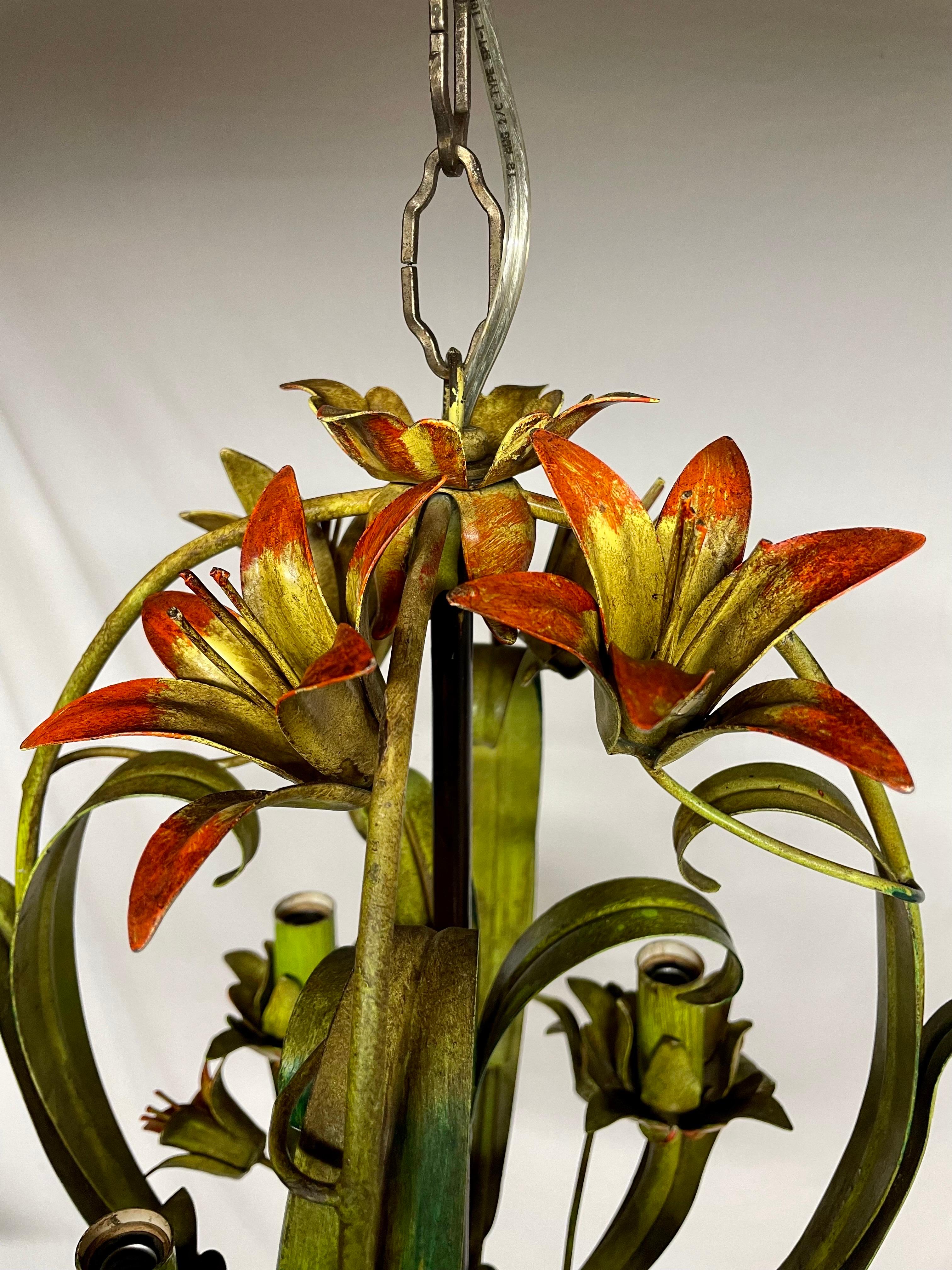 Italian floral tole four arm chandelier.   Lily flowers in yellow-reds with green leaves.  Some chipping paint that adds to the character. In good working condition. Measures: 12