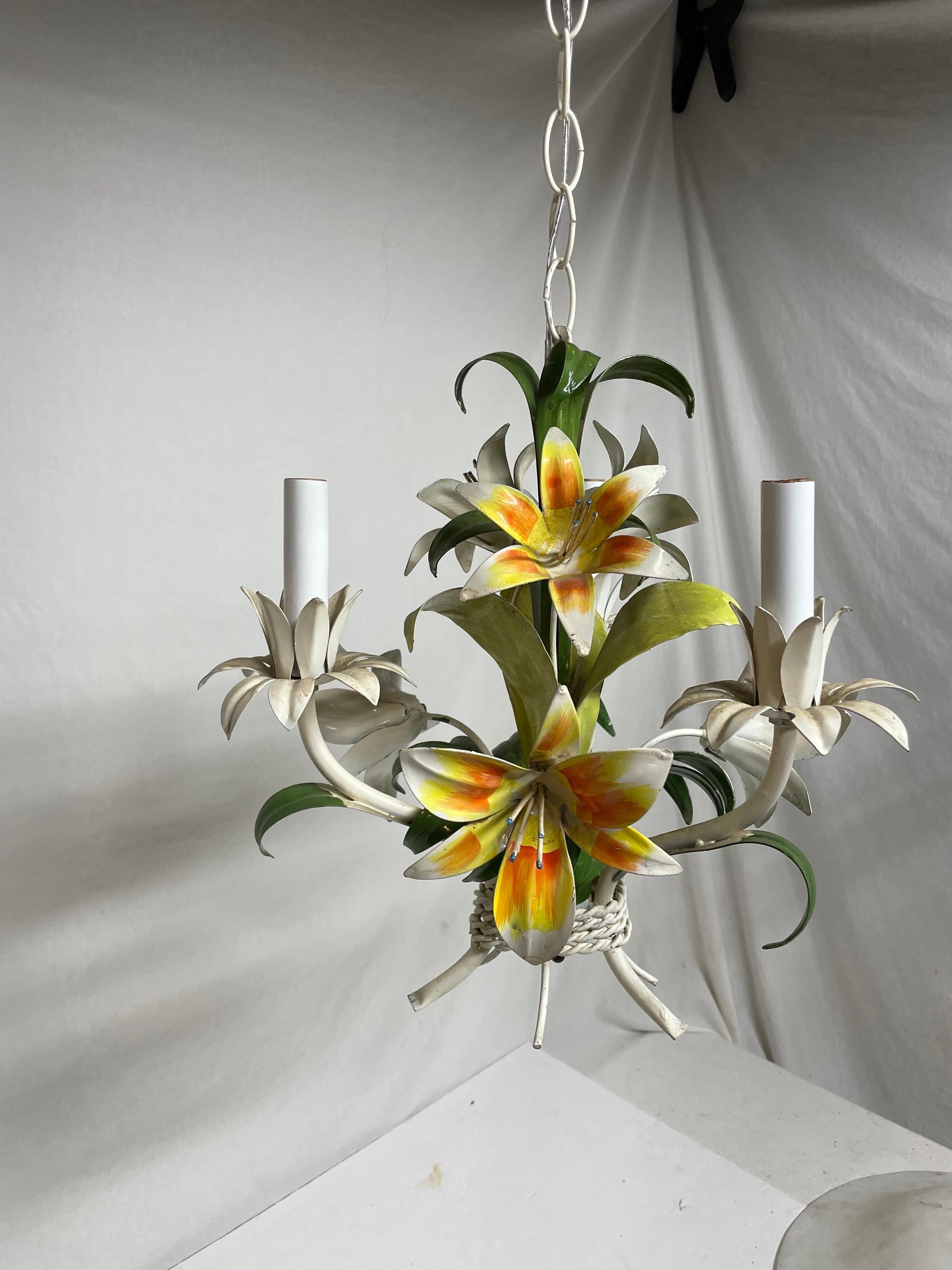  Italian floral tole three arm chandelier.  Lilly flowers in yellows, orange, pink, greens and cream. Some chipping paint that adds to the character. Rewired. and in good working condition. Measures: 13