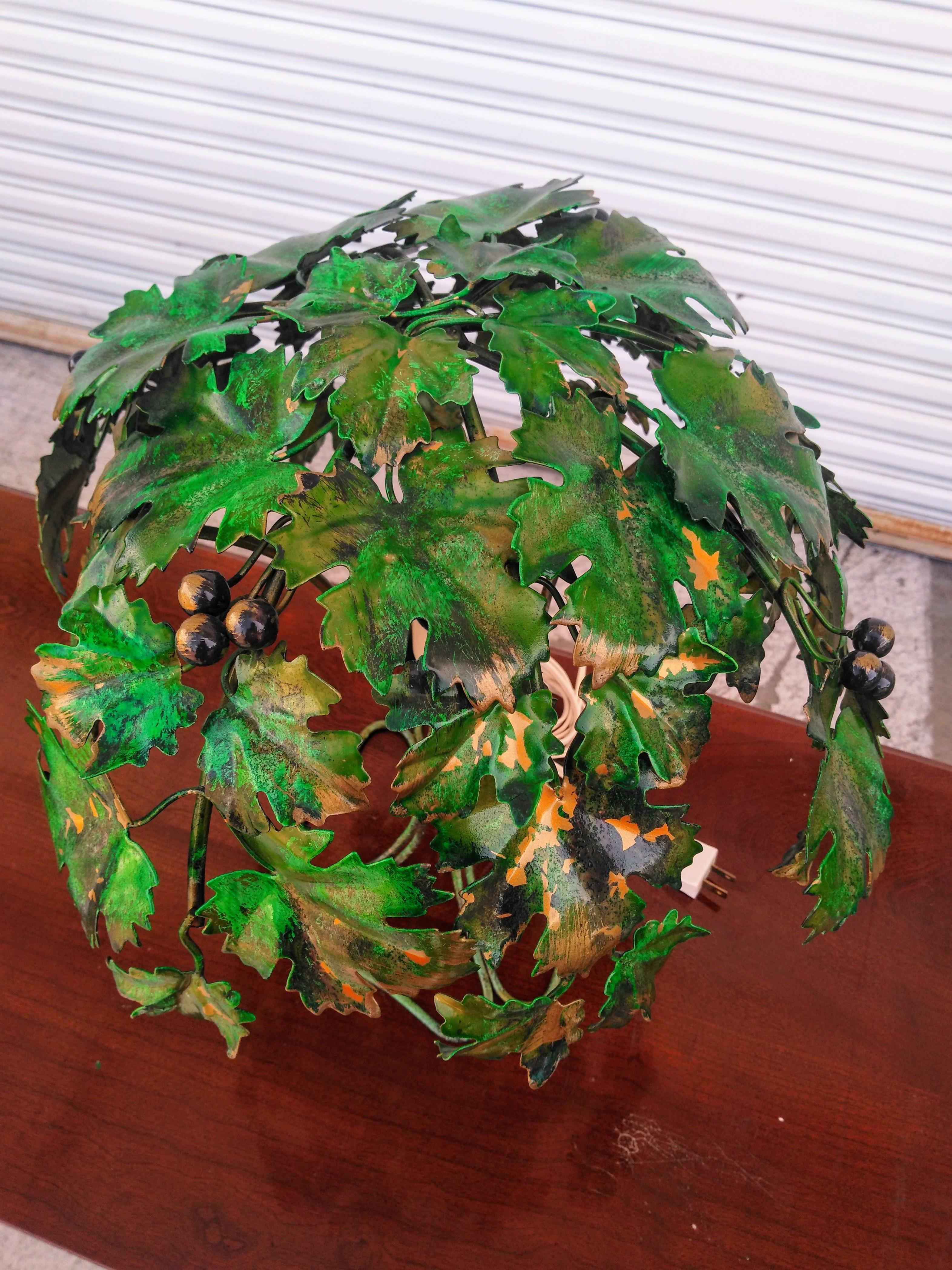 A very nice hand painted tole lamp crafted in Italy. It bears lots of foliage with grape accents all over. The base is composed of a high gauge wire shaped into the tree's trunk. 