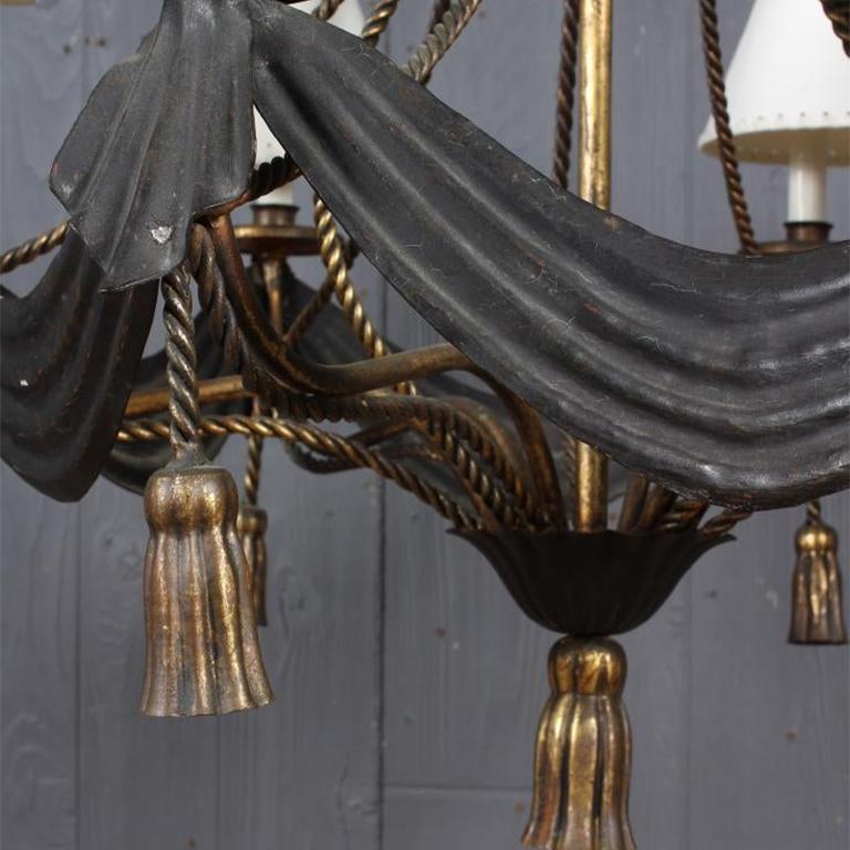 Italian tole 6-light empire style gilt hard-wired chandelier or candelabra with tassel rope and swagged or draped black accents. Metal is made to look as though it is draped with black fabric. This gorgeous rare chandelier features black iron metal