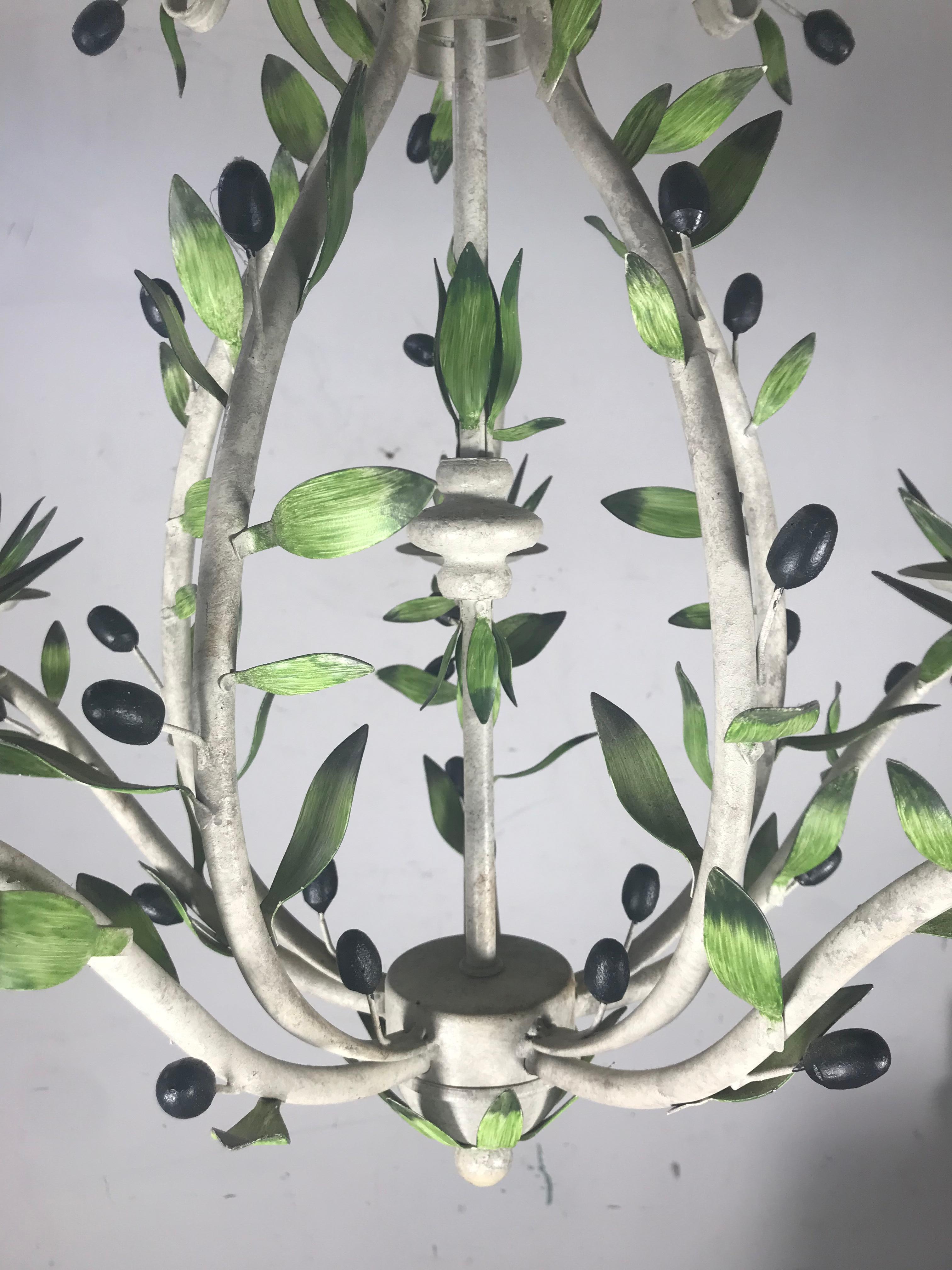 Mid-Century Modern chandelier, Italian Hollywood Regency. Item features scrolling white painted metal frame, green leaf accents, olives, leafy bobeche, five scrolling arms, and five lights, circa mid-20th century, Italy.
