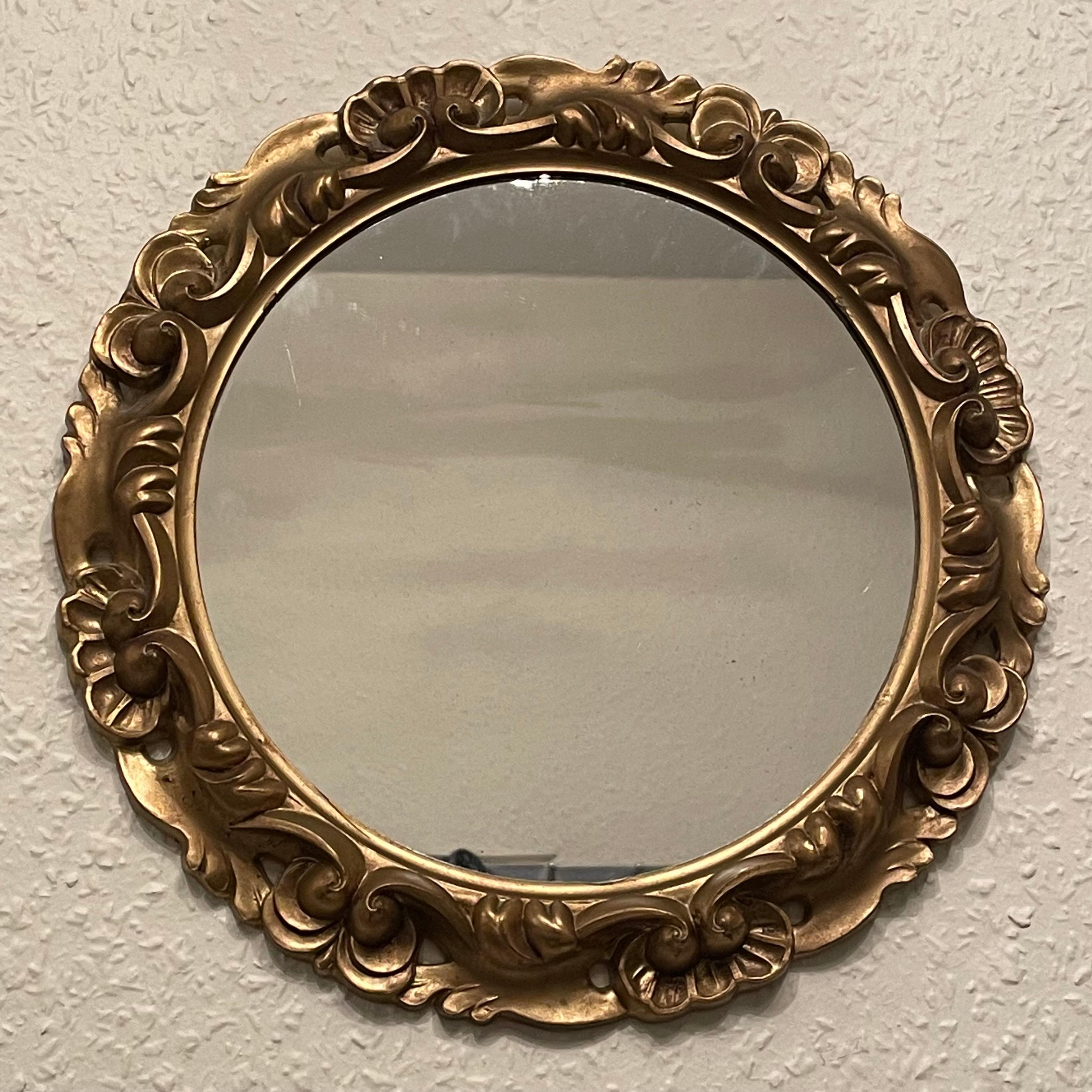 Un magnifique miroir en faïence. En résine dorée. Il mesure environ 11,75 pouces de diamètre, le miroir seul mesure environ 8,5 pouces de diamètre. Il se tient à environ 1