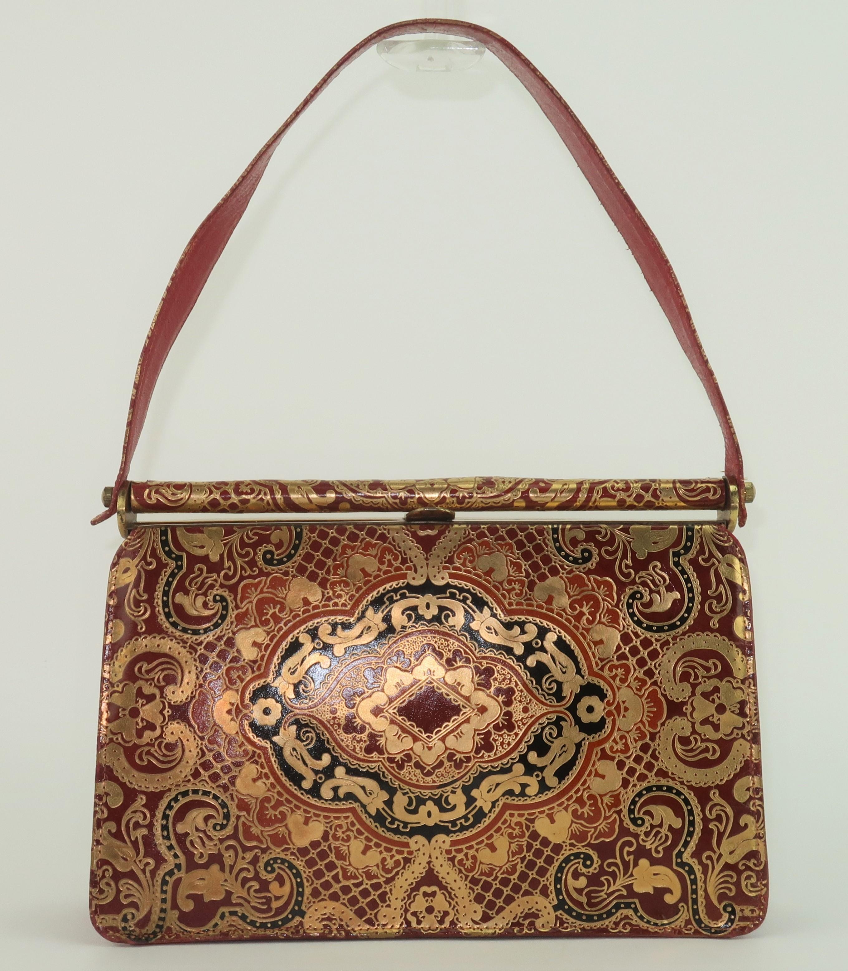 The golden romance of Venetian style tooled leather is truly a fashion staple with a timeless beauty.  This 1950's Italian handbag has a classic top handle silhouette in a rich and elegant gold and deep red tooled leather with black accents.  The