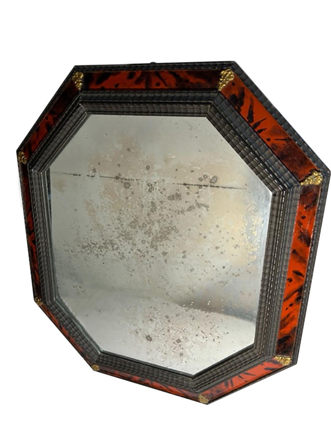 A carved wood and faux tortoiseshell eight sided mirror with ripple frame and brass accents. Italy, circa 1900. Numbered on back. With hook for hanging.