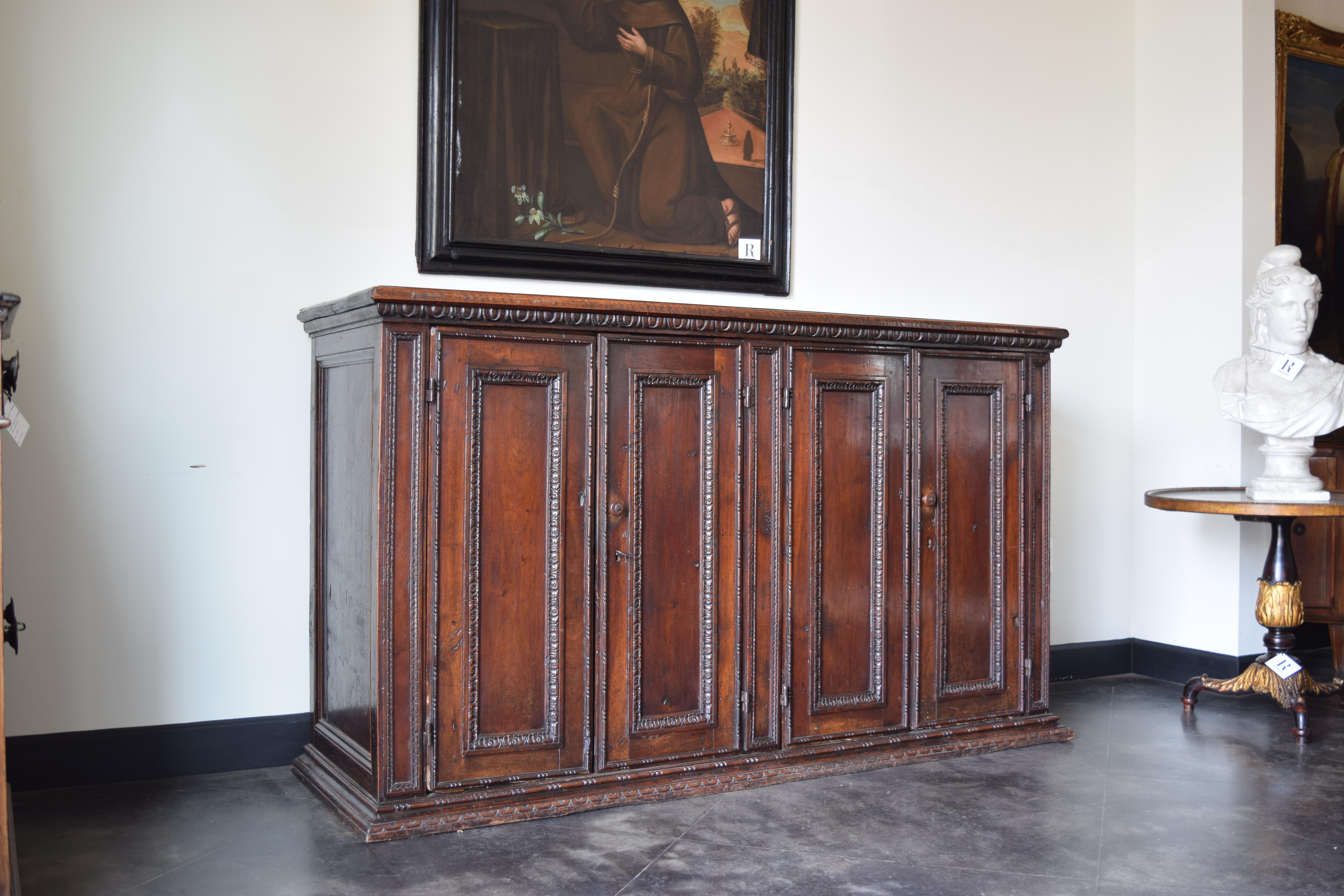 Dessus rectangulaire à deux panneaux avec bord mouluré au-dessus d'une caisse conforme avec bord supérieur godronné, les portes à quatre panneaux avec panneaux rectangulaires verticaux avec moulures sculptées, les portes avec charnières en fer