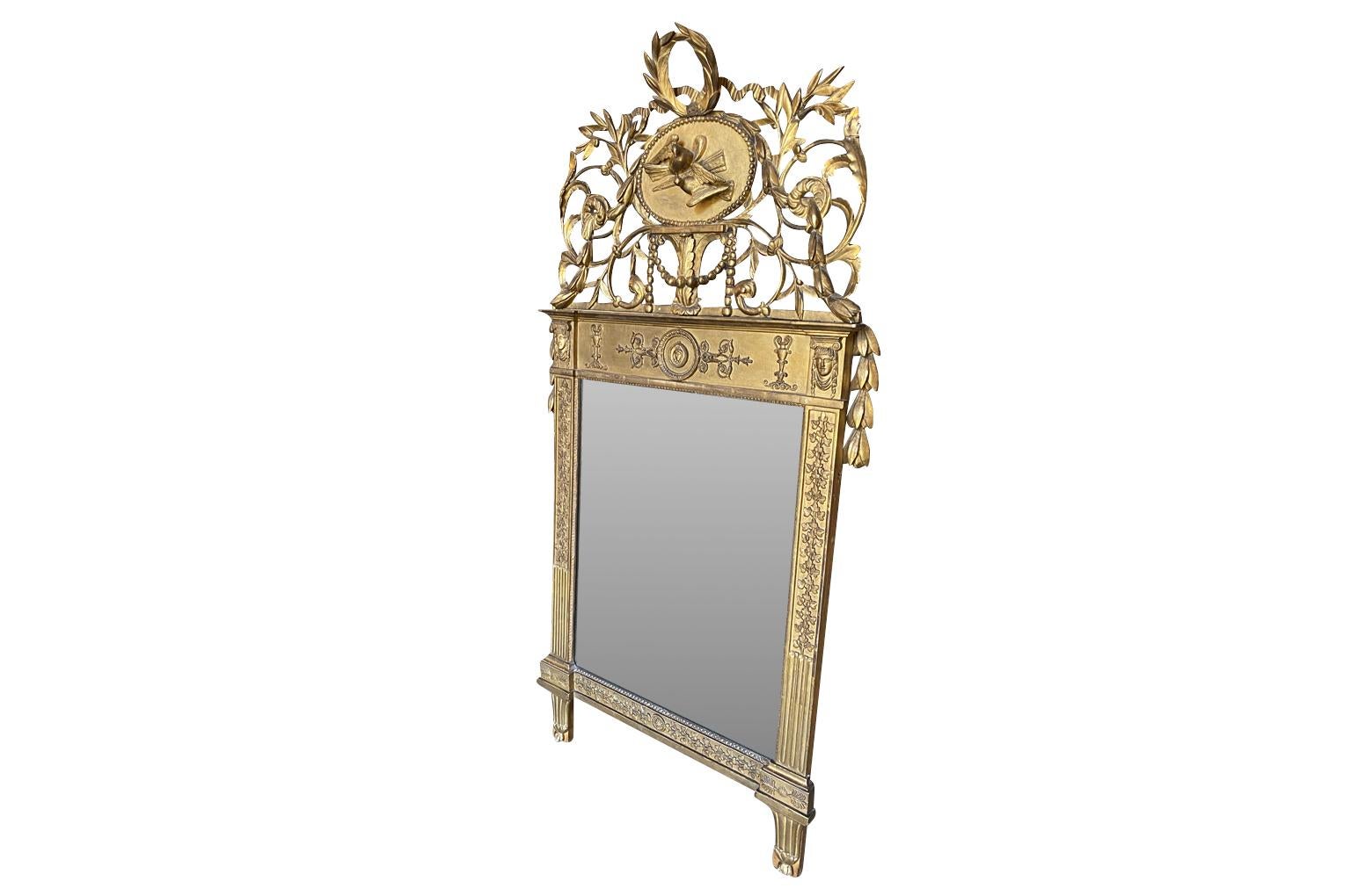 Un étonnant miroir de transition Louis XVI à Empire provenant de la région du Piémont en Italie.  Magnifiquement fabriqué en bois doré.  Le fronton est orné de colombes nuptiales et d'une couronne de lauriers et de guirlandes.  Le cadre est orné de
