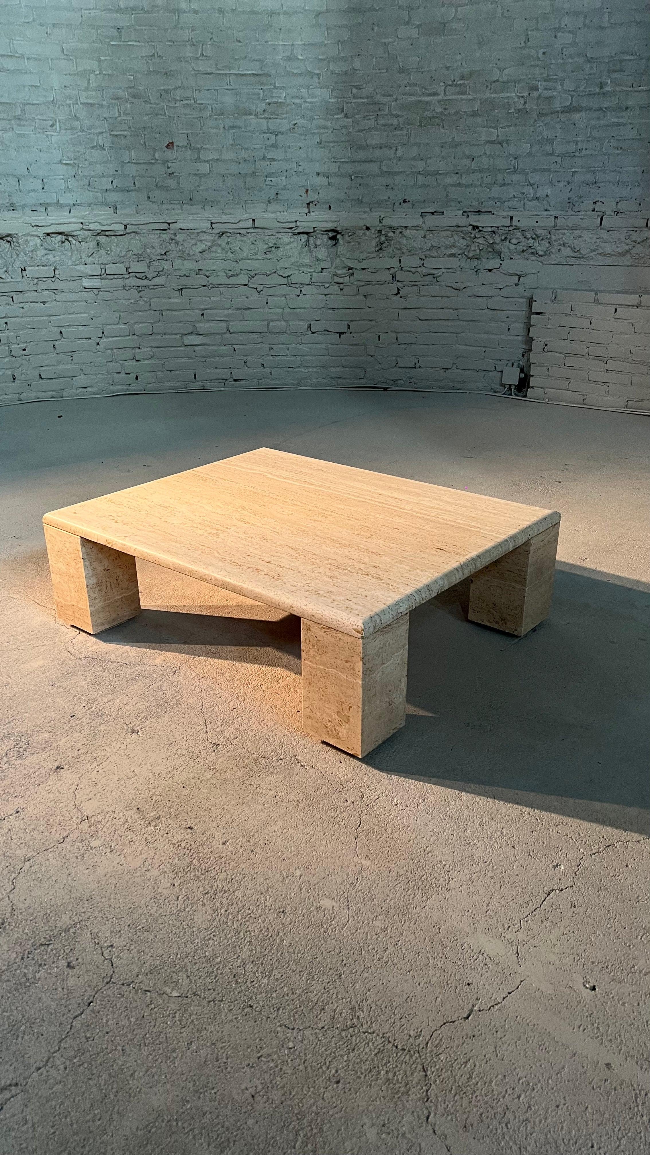 A large coffee table in Italian travertin dating from the 70's.

The table top rests on large blocks that can be used in 2 ways. The other leg option would creates a 2 cm slit between the legs and the table top. The marble has several beige tones
