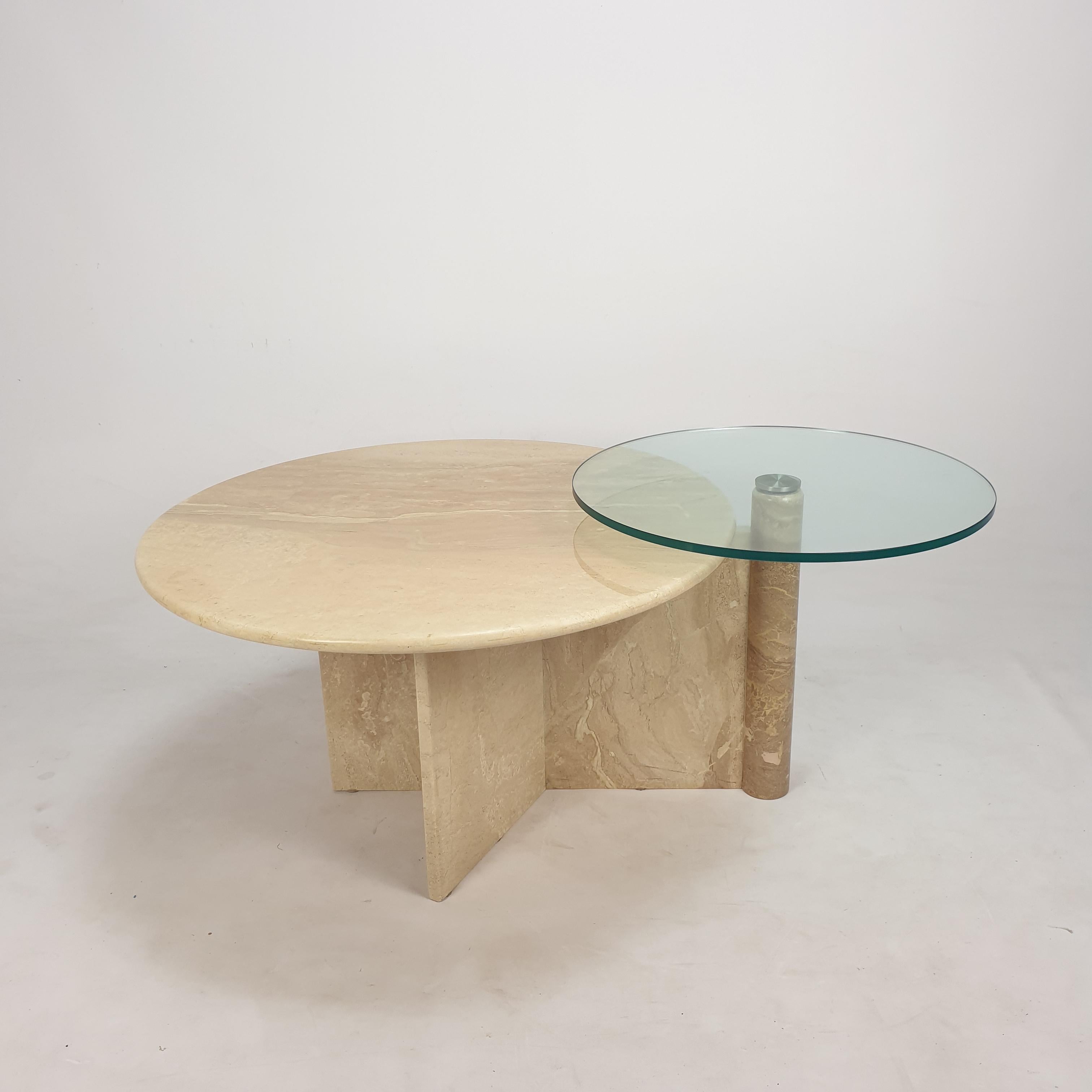 Très belle table basse italienne des années 80, fabriquée à la main en travertin. 
Une plaque ronde en travertin et une plaque tournante en verre.

La table est faite d'un magnifique travertin.