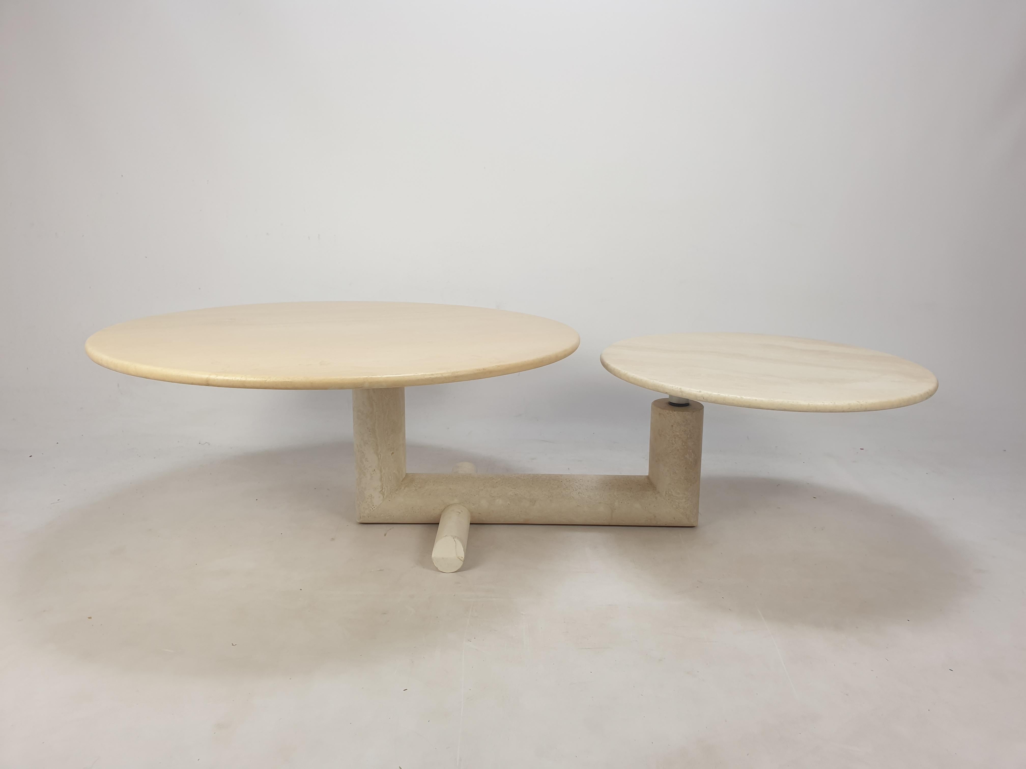 Lovely travertine coffee table, fabricated in Italy in the 80's. 

Two round plates on a very elegant base. 
The plates are turnable so you can vary the with (115 to 155 cm, 45 to 61 Inch) of the table (see the pictures). 

This rare table is