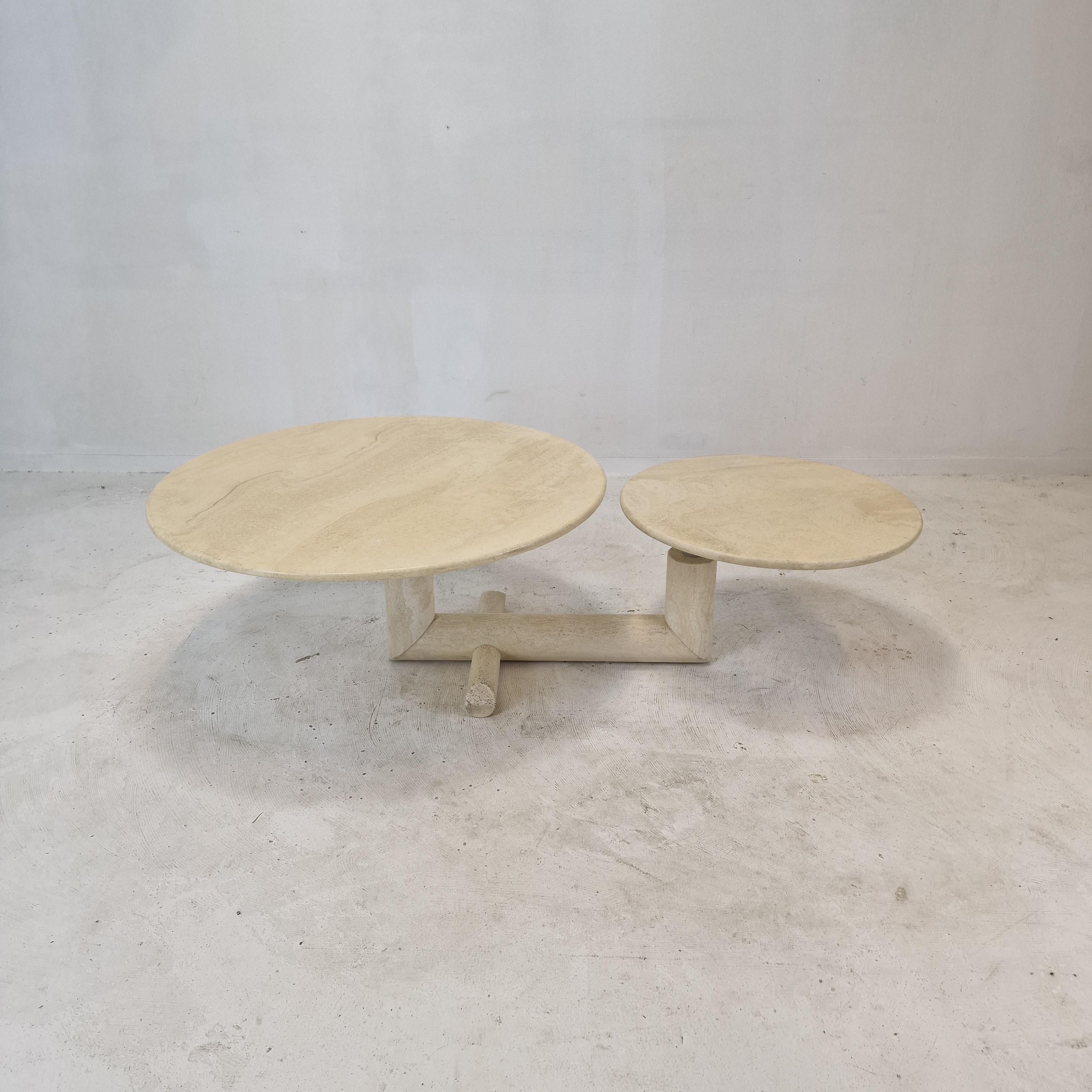 Lovely travertine coffee table, fabricated in Italy in the 80's. 

Two round plates on a very elegant base. 
The plates are turnable so you can vary the with (117 to 153 cm, 46 to 60.2 Inch) of the table (see the pictures). 

This rare table is