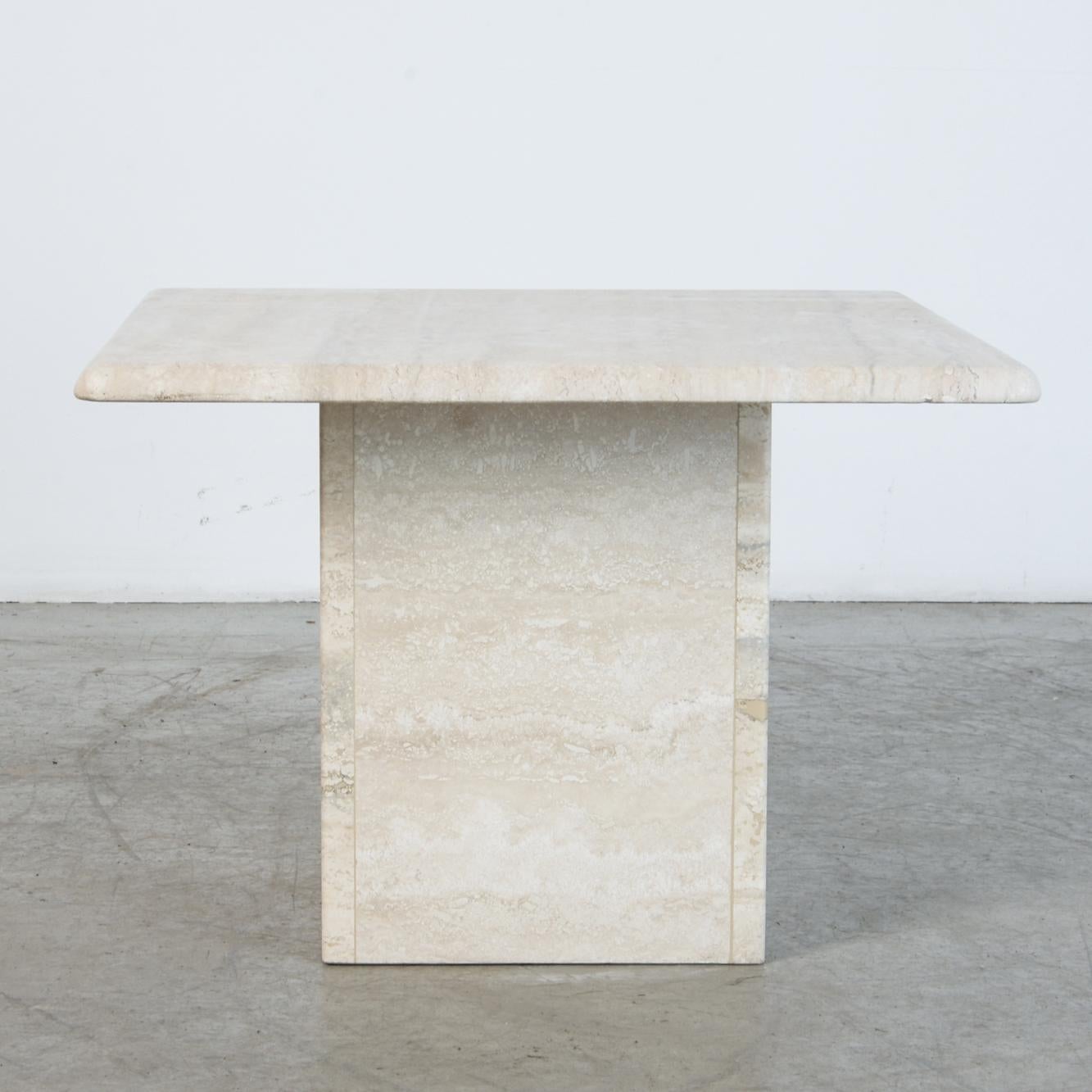 A refined travertine coffee table or pedestal, with rounded square top and base. A material rich in itself, echoing classical sculpture. Associations from antiquity to 1970s kitsch, this is a piece that truly fits in any space. At a modestly scaled