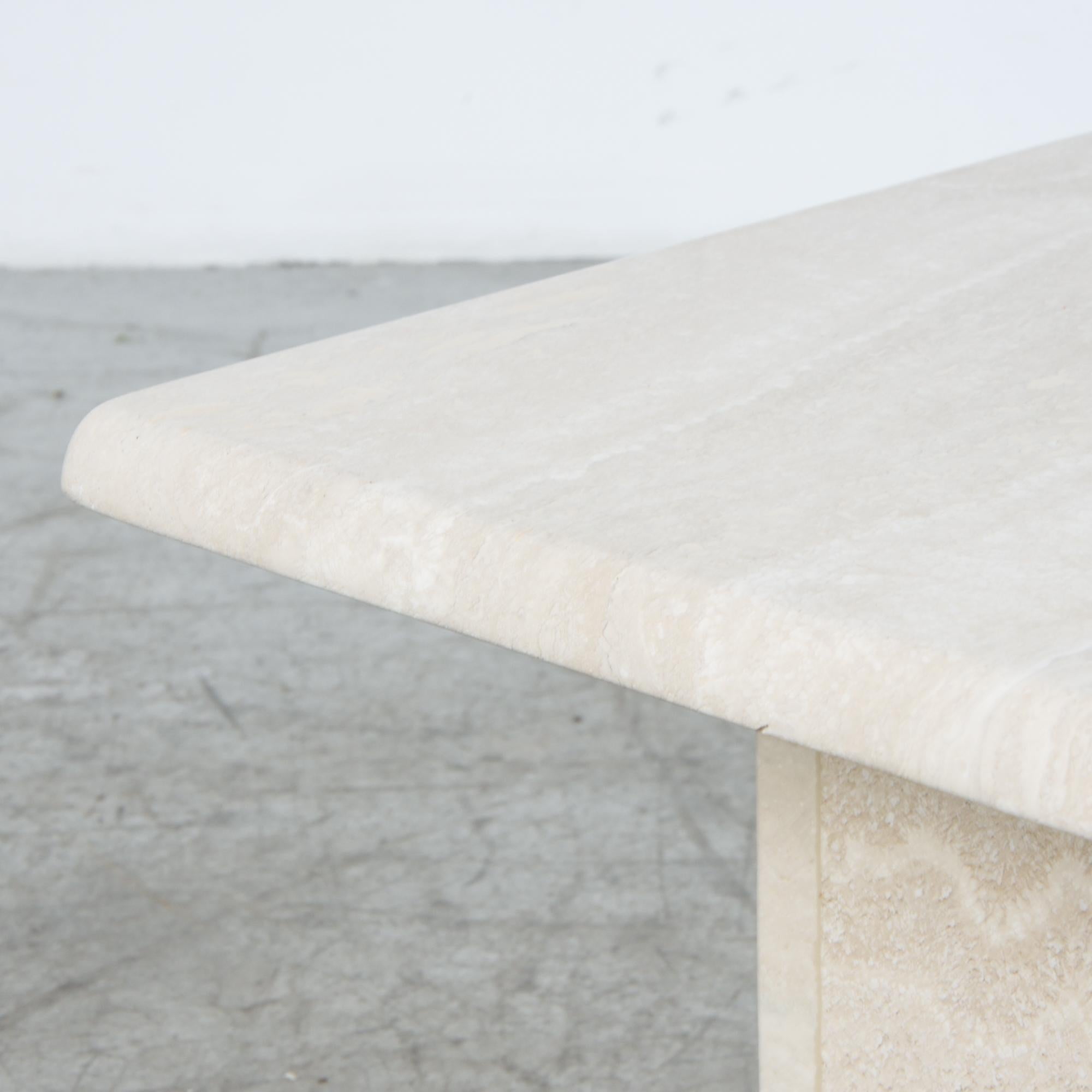 A refined travertine coffee table or pedestal, with rounded square top and base. A material rich in itself, echoing classical sculpture. Associations from antiquity to 1970s kitsch, this is a piece that truly fits in any space. At a modestly scaled