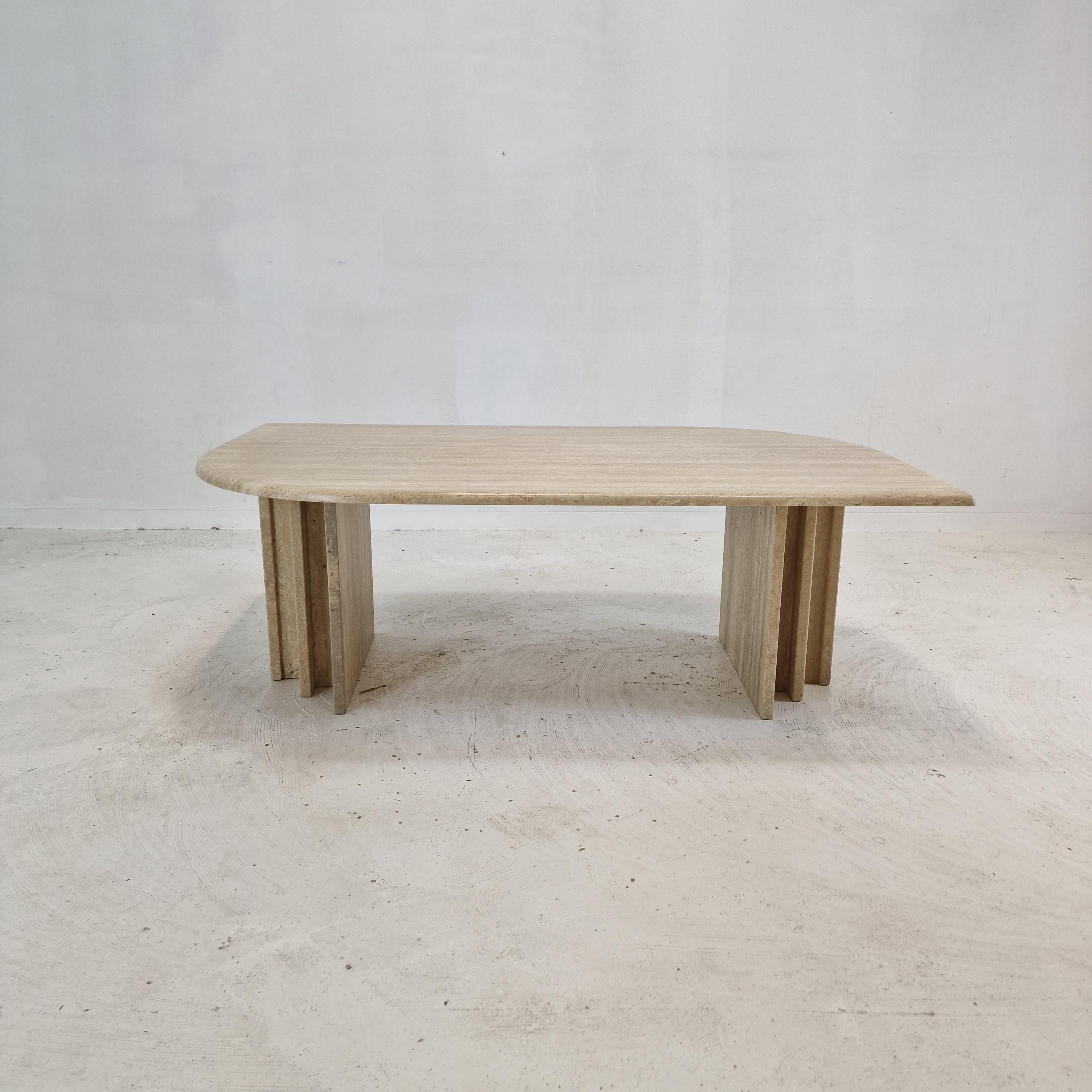 Très élégante table basse italienne fabriquée à la main en travertin.

Le magnifique plateau en forme de rectangle est arrondi sur le bord. 
Il est fait d'un magnifique travertin.

La base est composée de deux pièces séparées, il est possible de