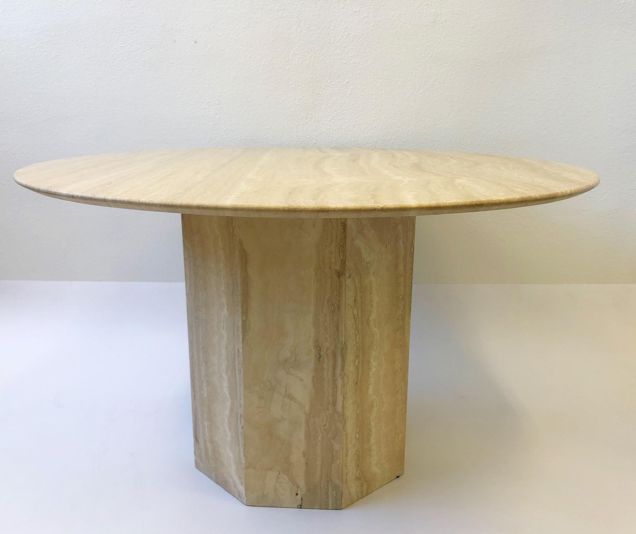 A glamorous 1970s Italian travertine round dining table with an octagonal shape base. The top has a knife edge.
Overall dimensions: 47.25” diameter, 28.25” high.