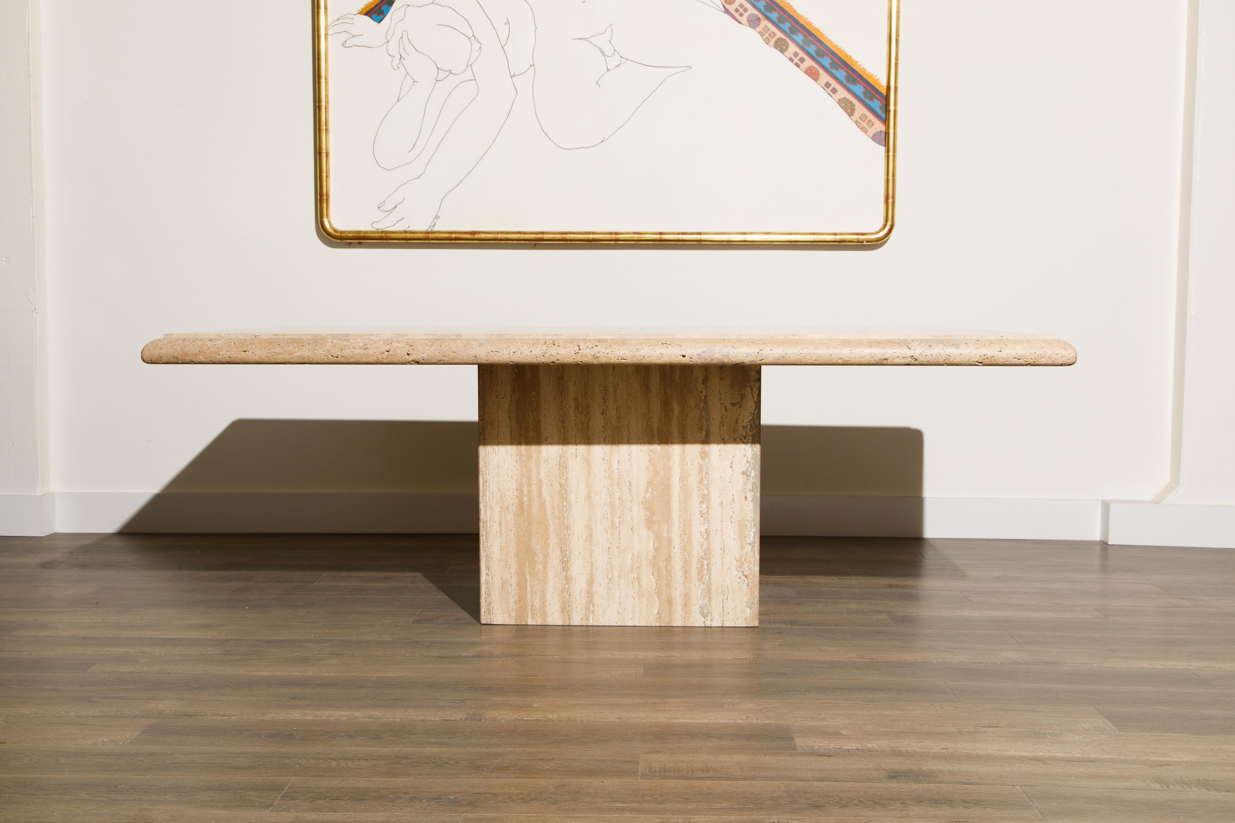 An incredibly stylish Italian travertine dining table by Lima Italy, in the 2000s, featuring a large rectangular top with gorgeous travertine veining and a natural unfilled Travertine edge which wraps around all sides, sitting on top of a rectangle