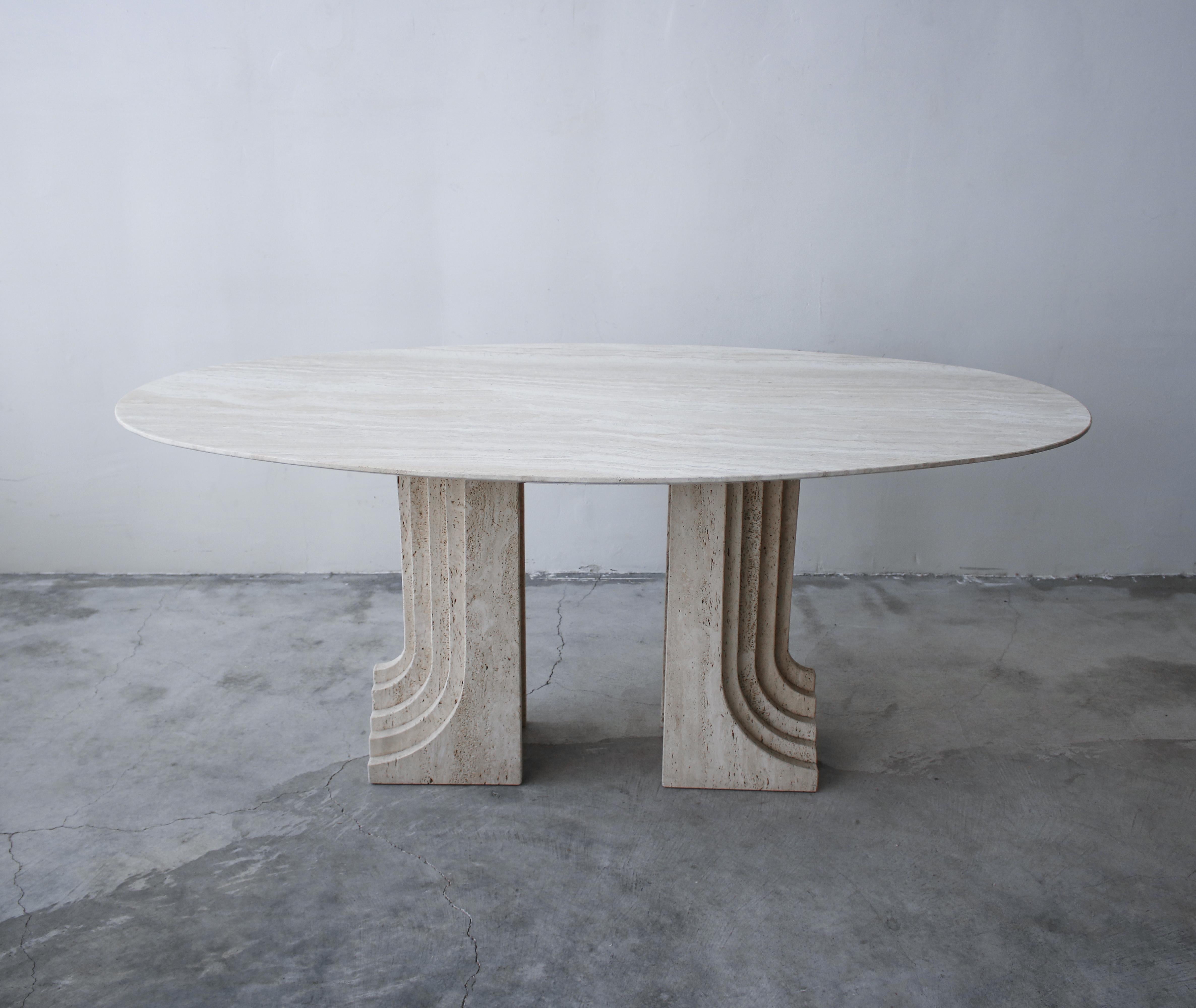 Nothing short of amazing. A gorgeous solid travertine dining table by Carlo Scarpa. A gorgeous polished travertine top is supported by a pair of honed travertine pedestals designed in a staggered, architectural pattern giving them extreme depth and