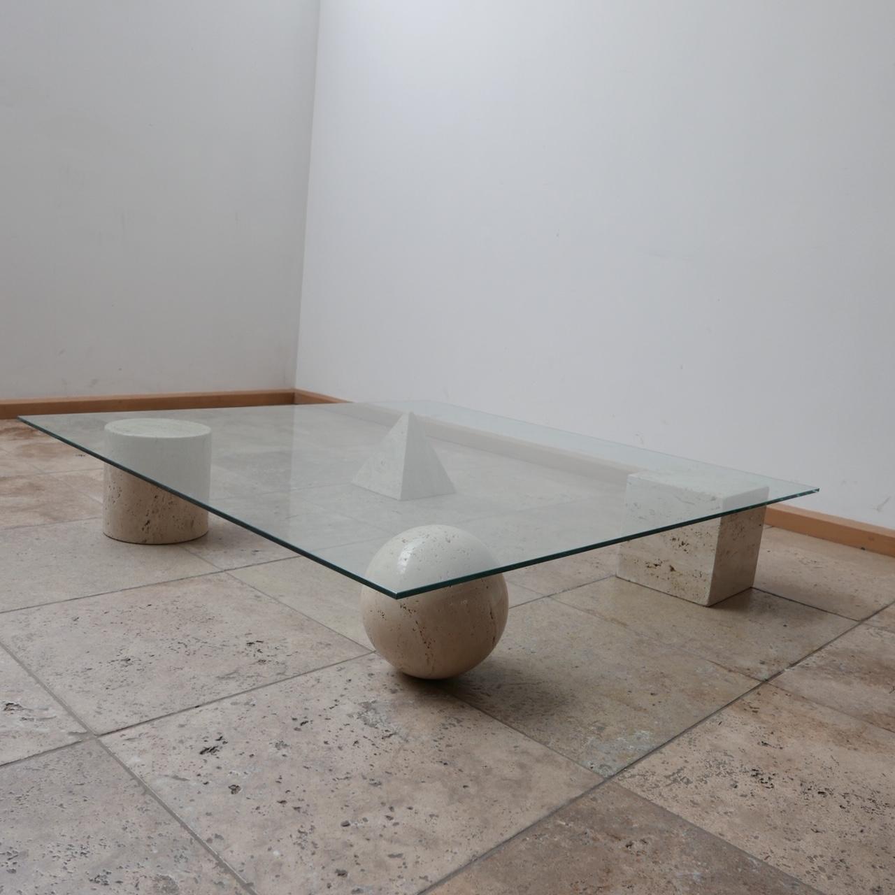A travertine geometric shaped coffee table with a glass top. 

Attributed to Massimo and Lella Vignelli. 

Italy, c1970s. 

The geometric shapes are solid travertine, they have some scuffs but generally good condition, age commensurate with age.