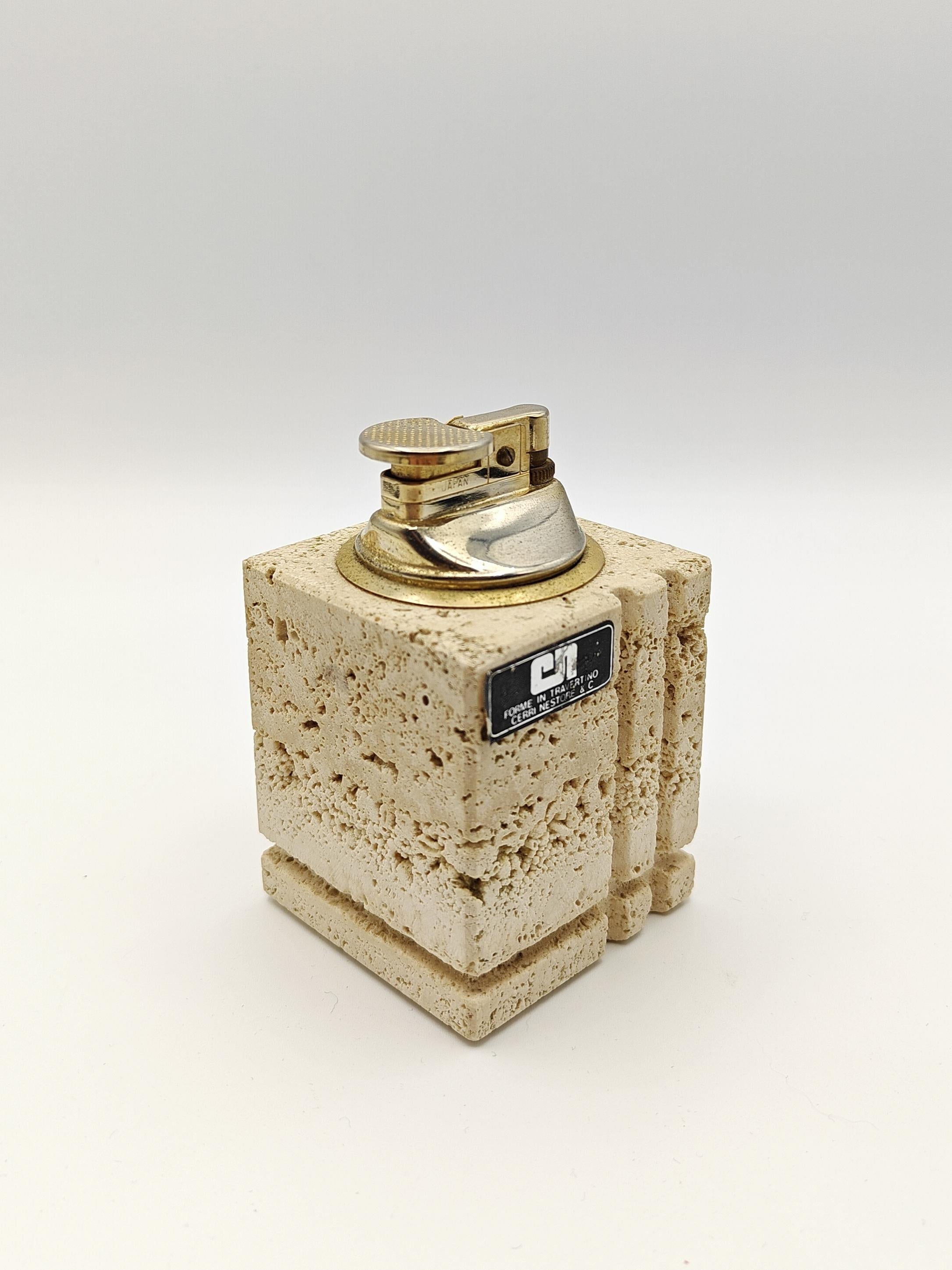 Iconic table lighter from the 70s in travertine and brass. This table or desk accessory is totally functional. The small reservoir of this lighter can be easily removed to facilitate the refilling of butane gas or Zippo gas. Of Italian origin, but