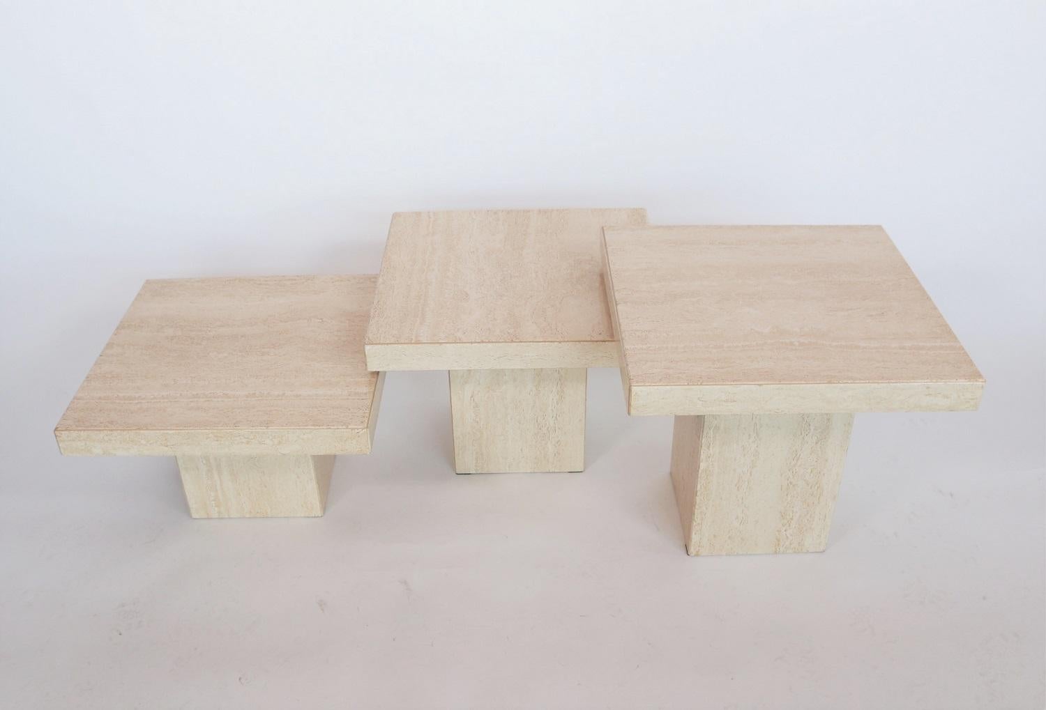 Gorgeous set of three different travertine marble coffee tables from the rich Italian Regency period during the 1970s. Made in Italy.
The tables have a beautiful cream color and gorgeous marble structure.
The three square bases are of different