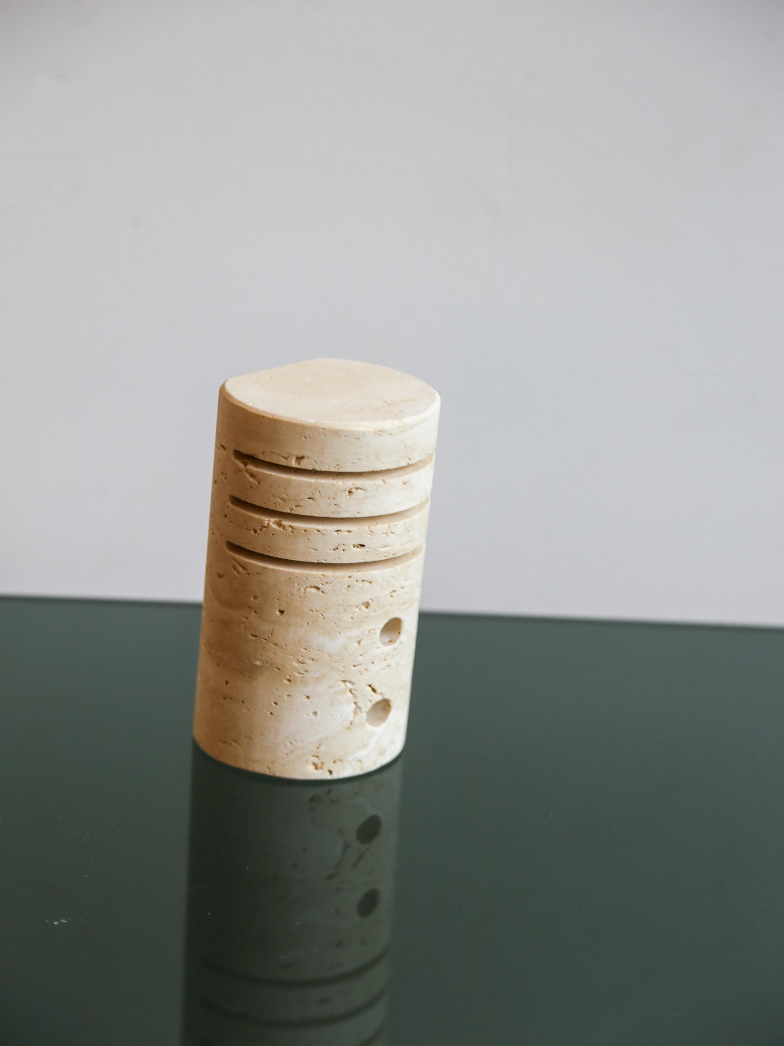 A minimalist desk accessory in honed natural travertine, handcrafted in Italy during the 1970s. Sculpted into a cylindrical form with carved ridges, this piece offers slots for both a writing instrument and business cards or notes, elegantly