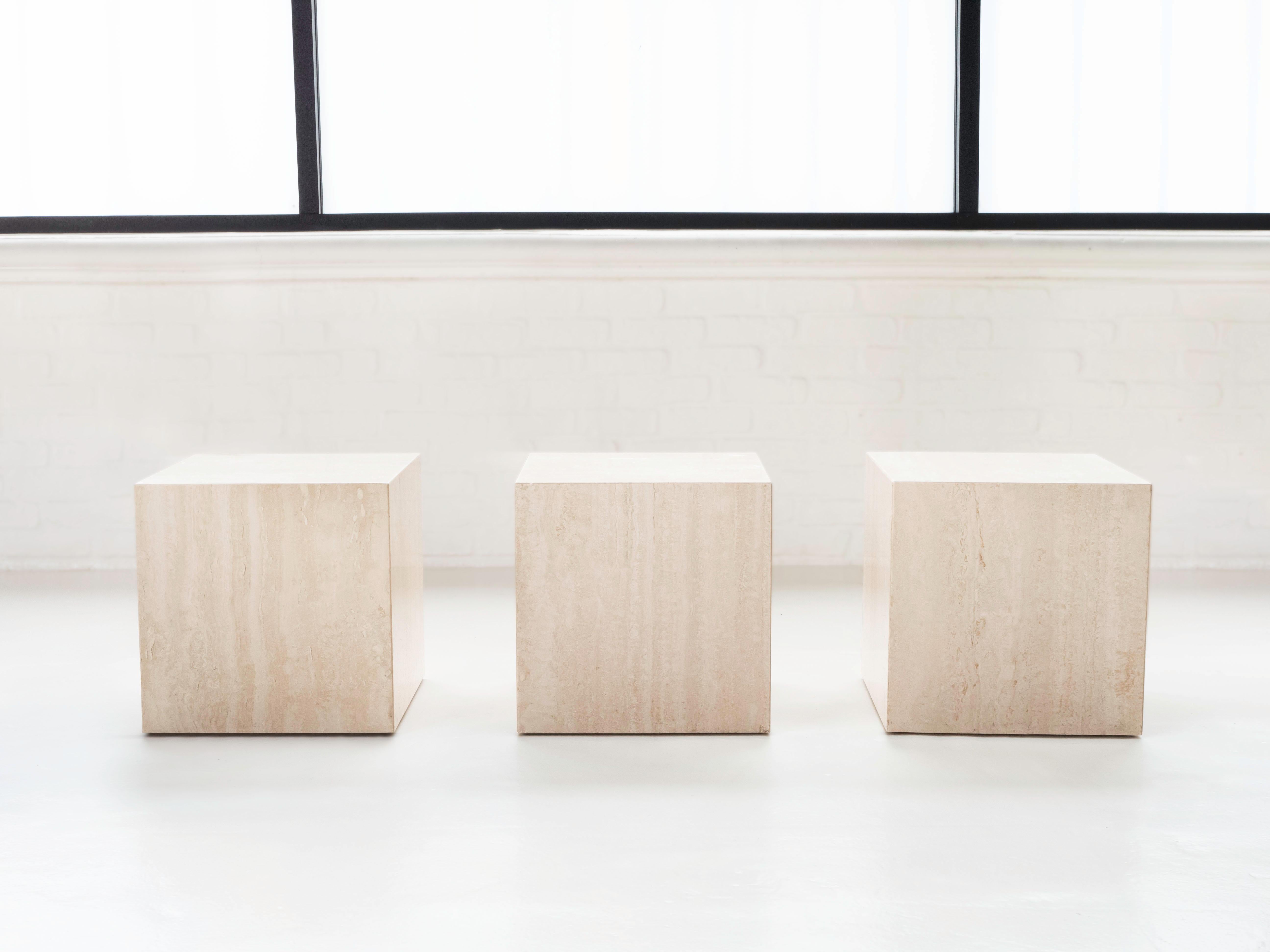 Italian travertine set of 3 cube side tables, circa 1970's.  Versatile pieces that can be combined to create one long continuous section, or spread apart for use as individual tables.  All in good original condition, some light chipping on a few